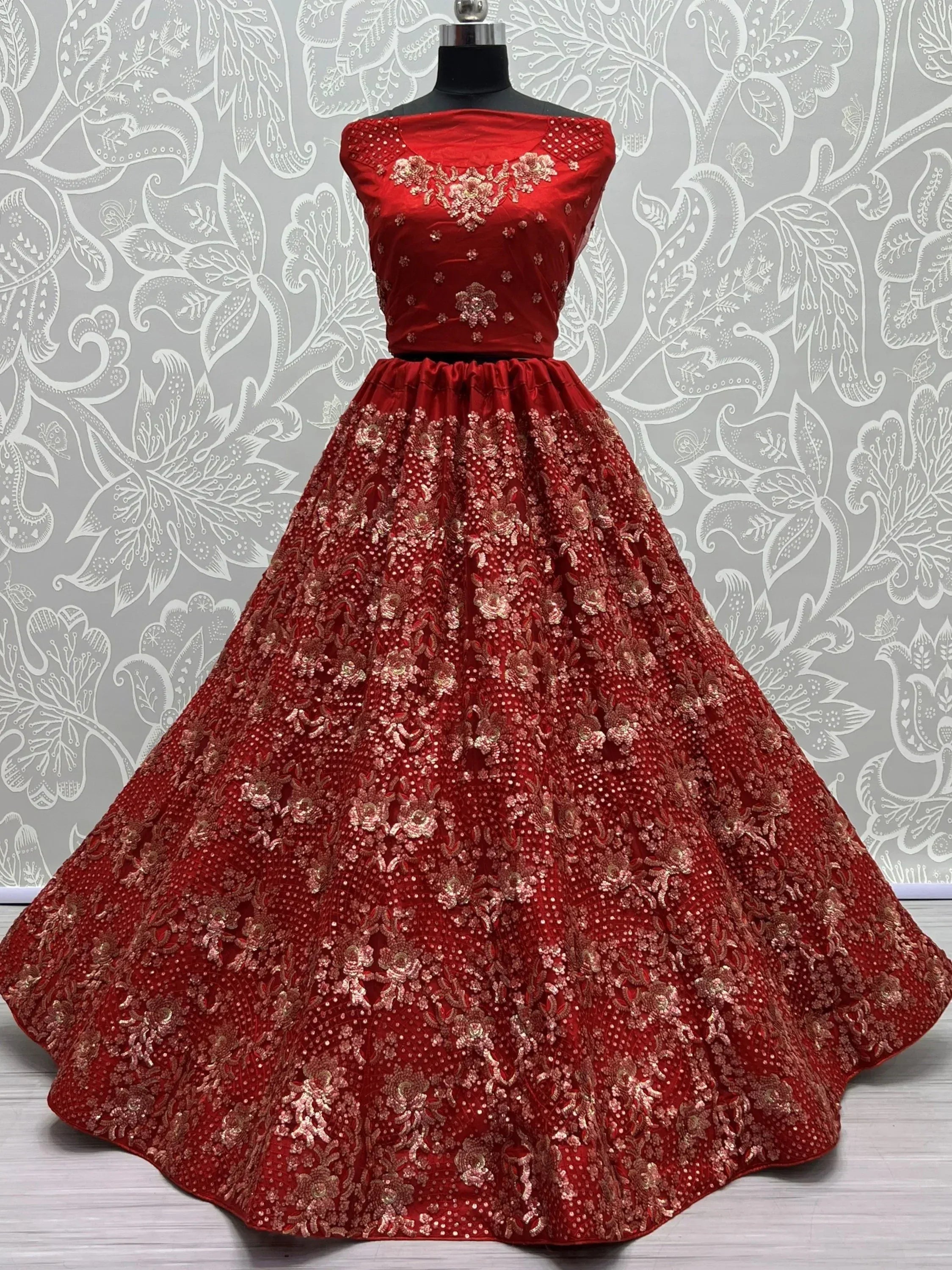 Red embroidered ethnic gown with floral embellishments, perfect for Indian weddings and festive occasions.