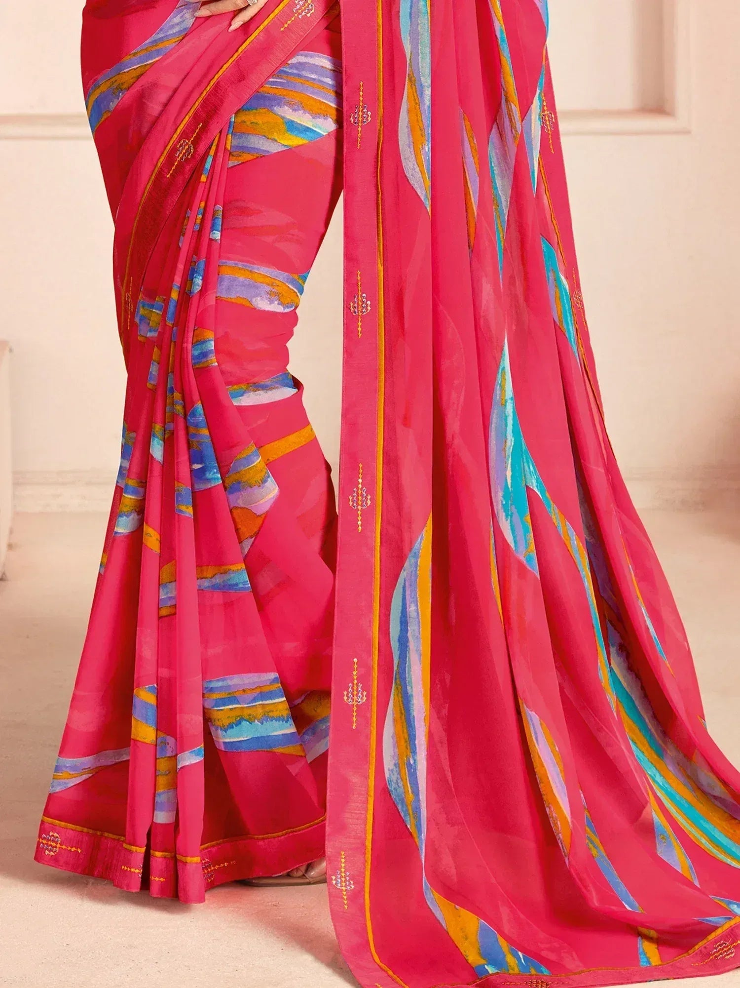 Vibrant pink saree with abstract blue and gold print, perfect for ethnic occasions