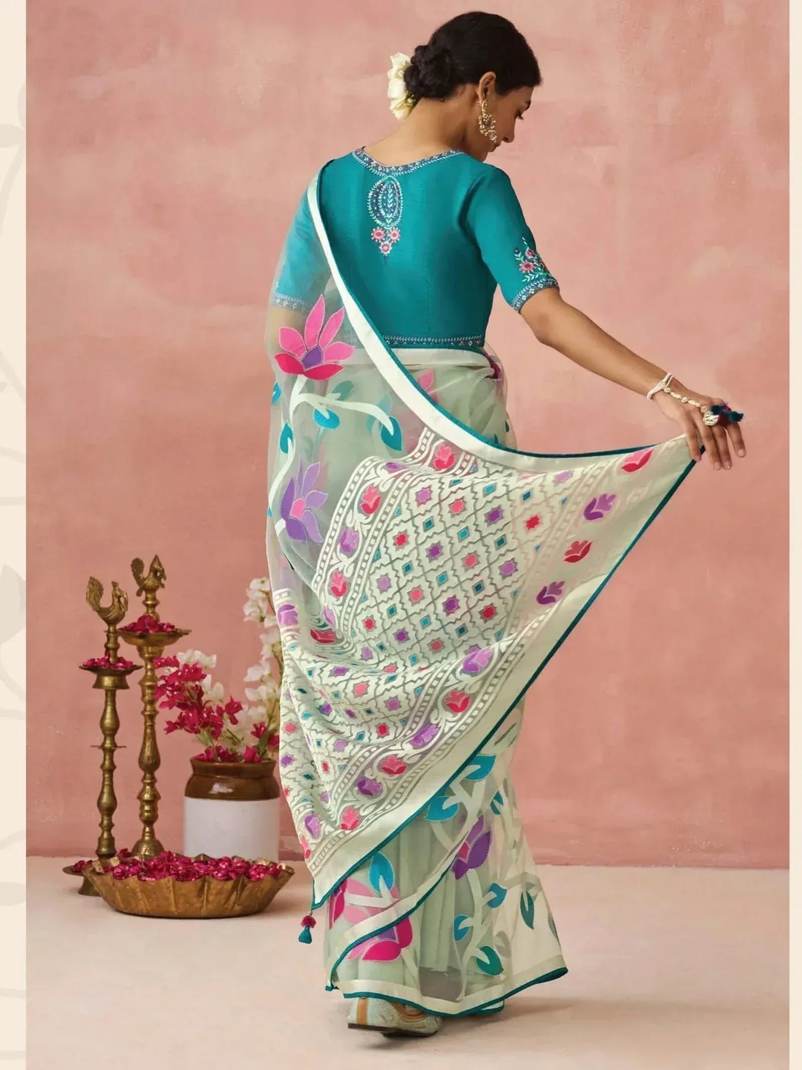 Woman in floral printed saree with embroidered teal blouse, showcasing ethnic Indian wear