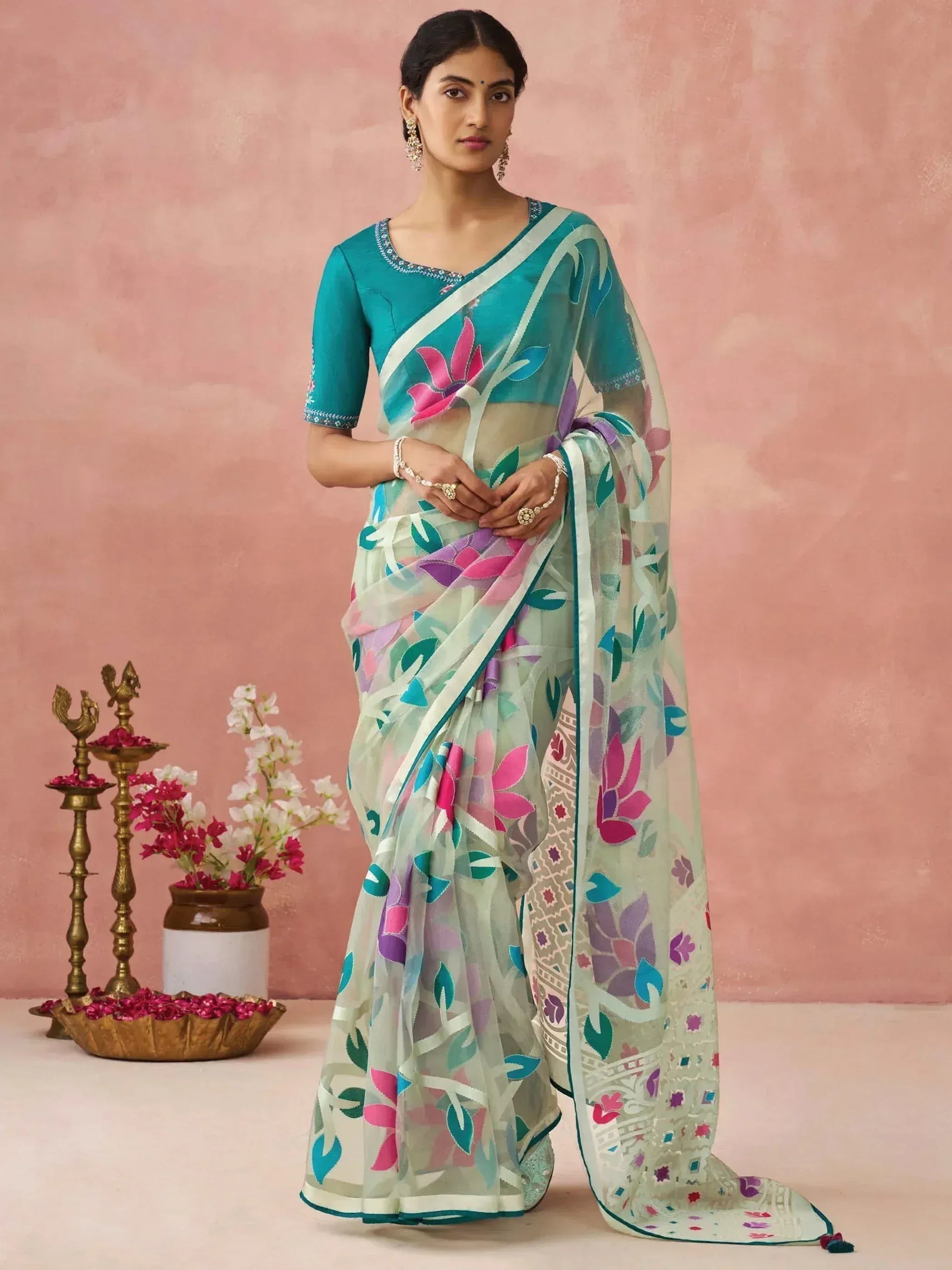 Woman in floral printed saree with teal blouse, ethnic Indian wear for festive occasions