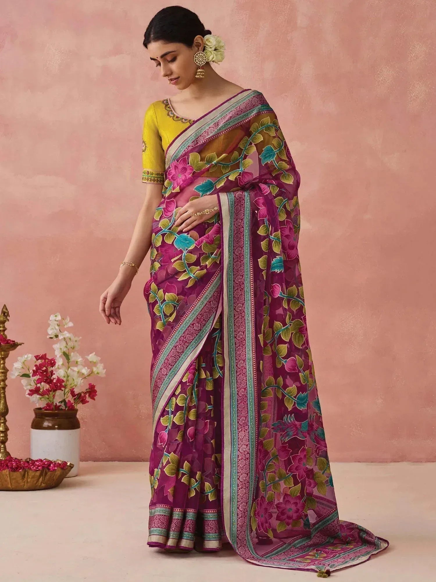 Woman in vibrant purple floral saree with yellow blouse, ethnic Indian wear for festive occasions