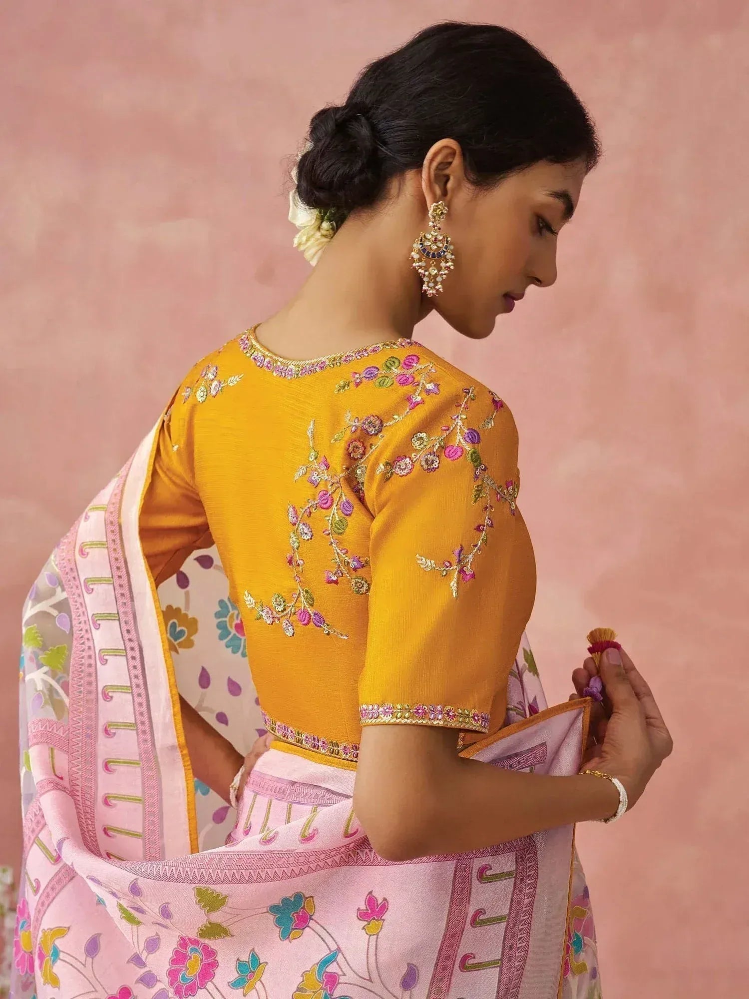 Woman in yellow embroidered blouse with pink floral saree, traditional Indian ethnic wear