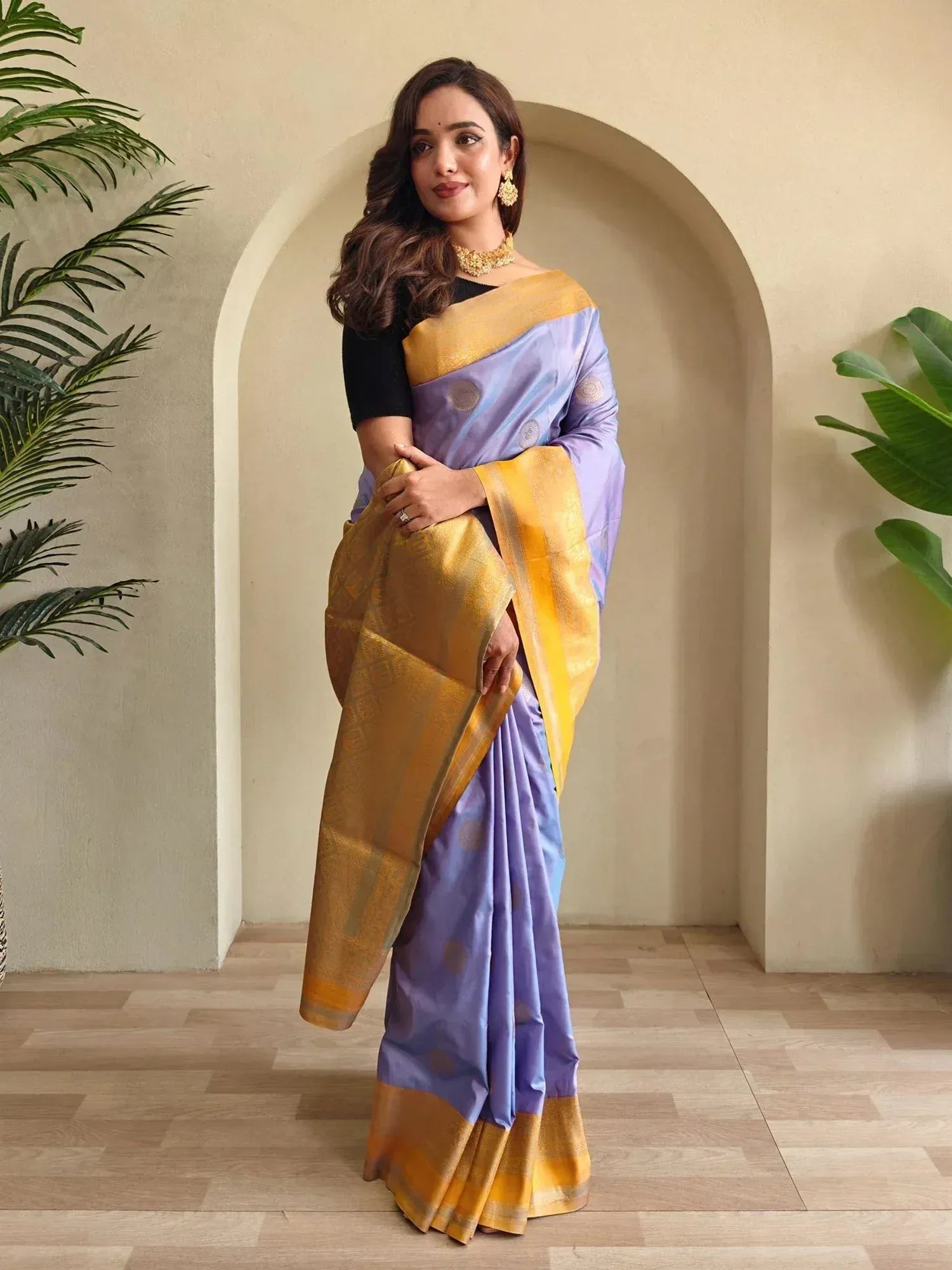 Woman in lavender and gold designer saree with intricate border, perfect for ethnic occasions