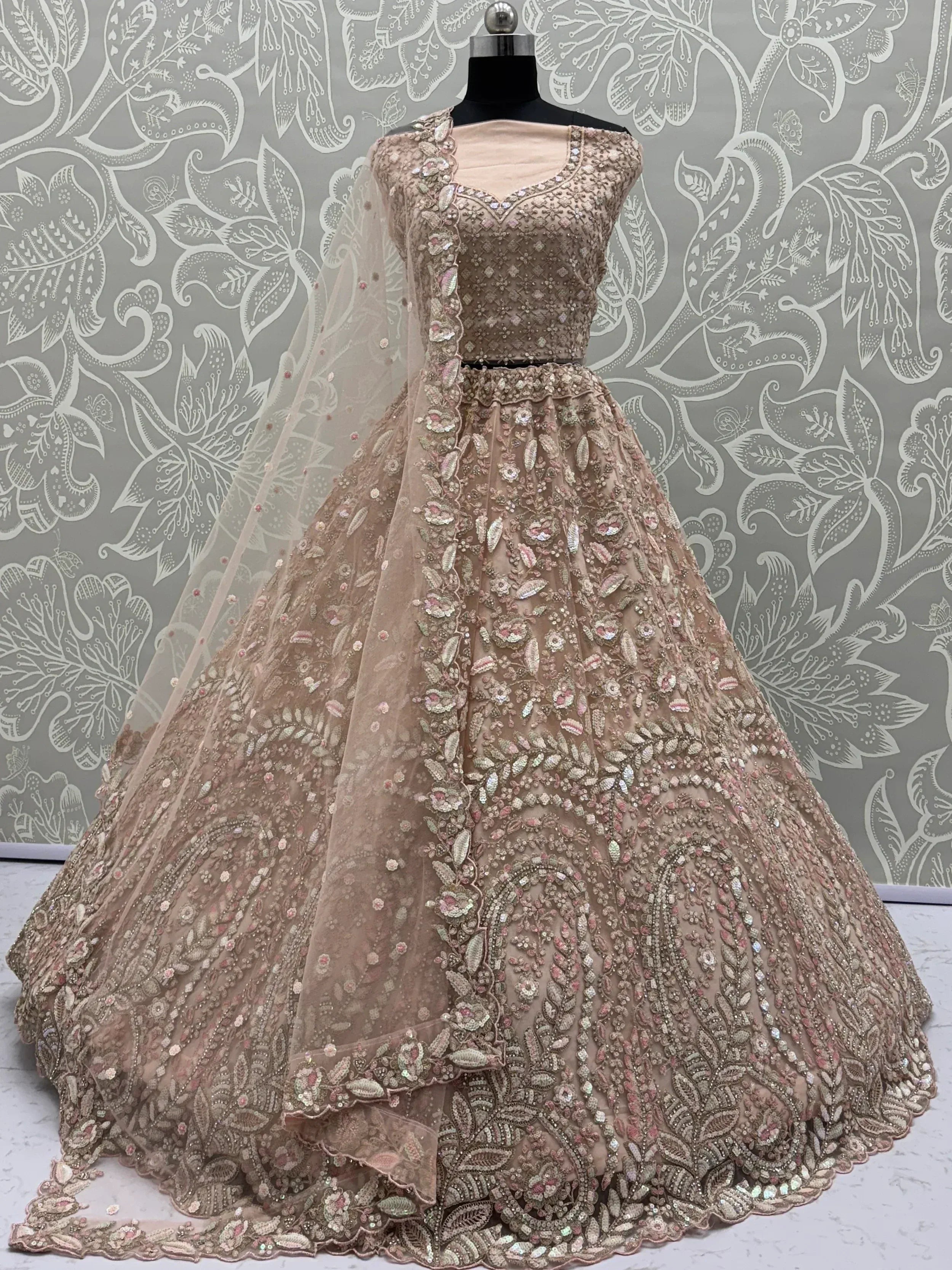 Elegant beige designer lehenga choli with intricate floral embroidery and sequin work, perfect for Indian weddings.