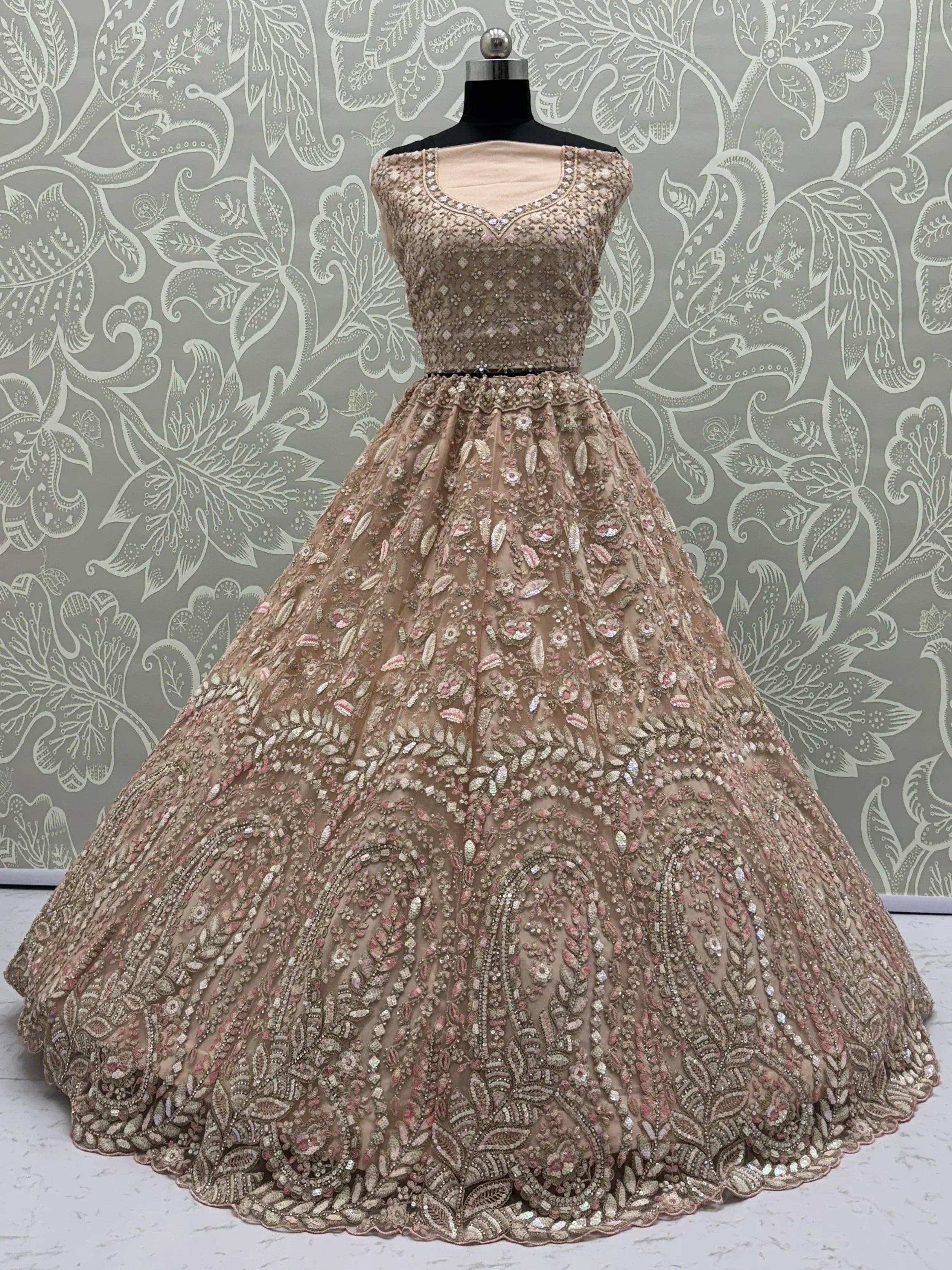 Elegant beige designer lehenga choli with heavy floral embroidery and sequins, perfect for Indian weddings.