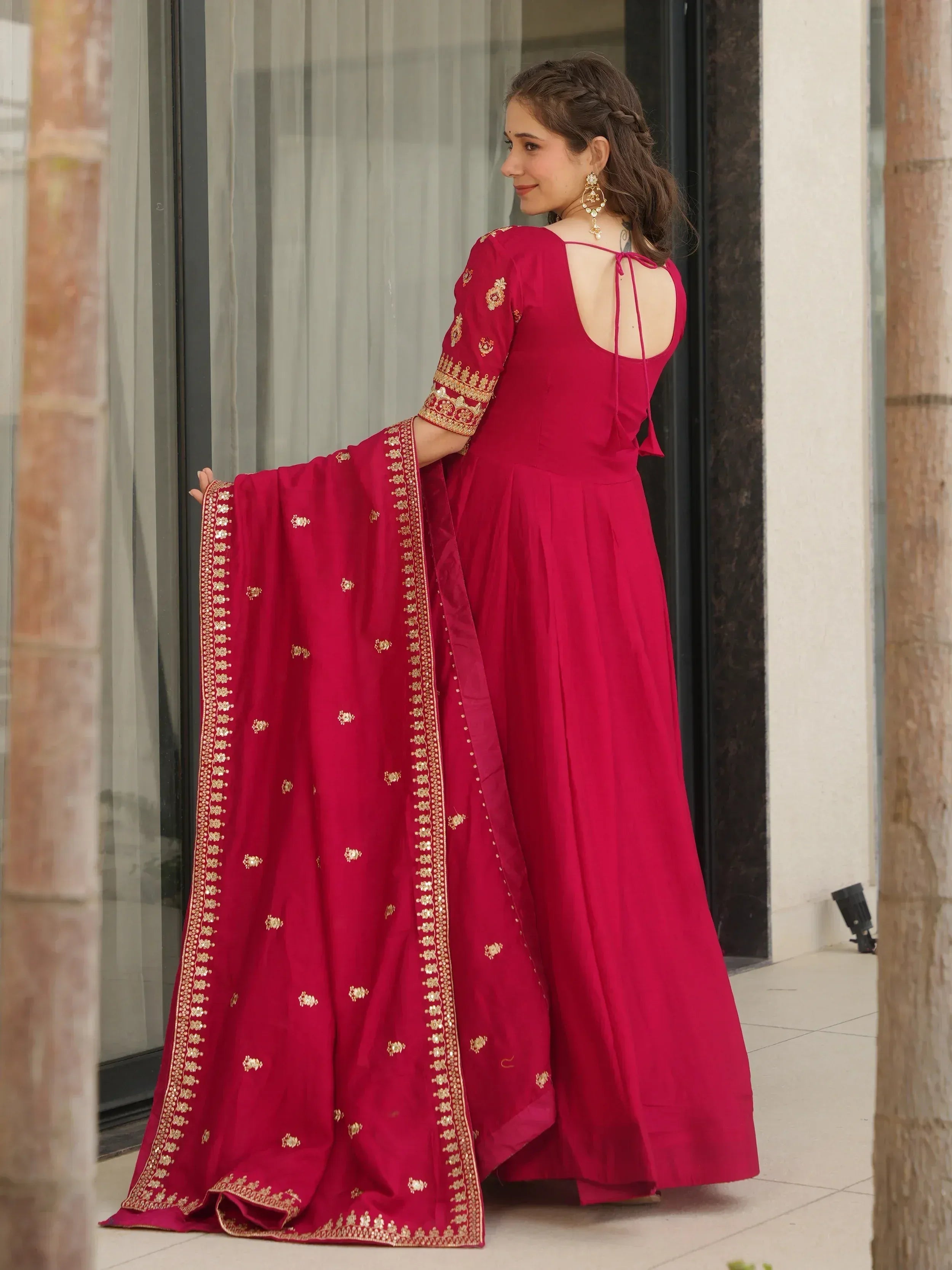 Red ethnic gown with gold embroidery and back tie, paired with matching dupatta for Indian wear