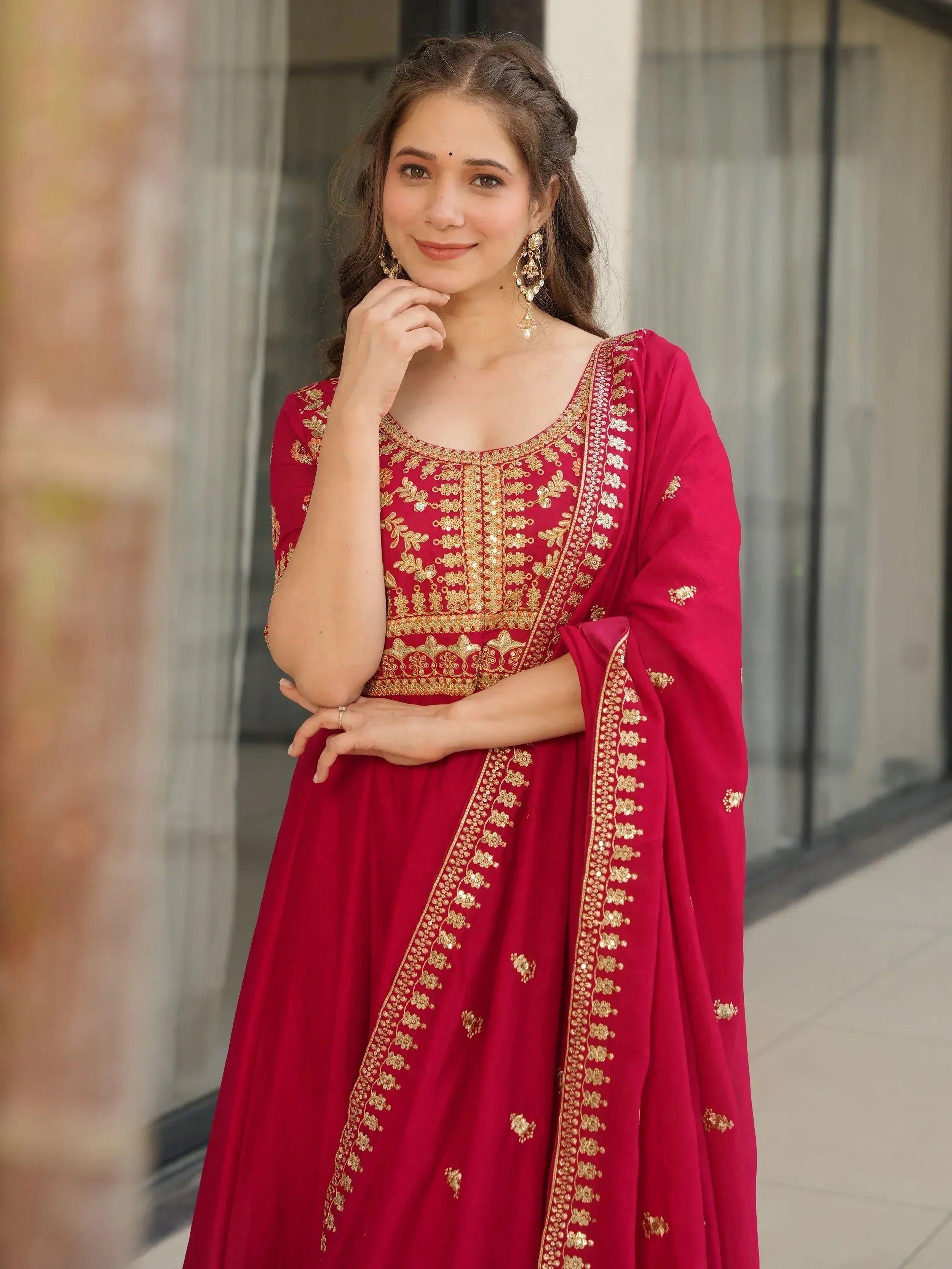 Red ethnic gown with gold embroidery, perfect for Indian celebrations and festive occasions.