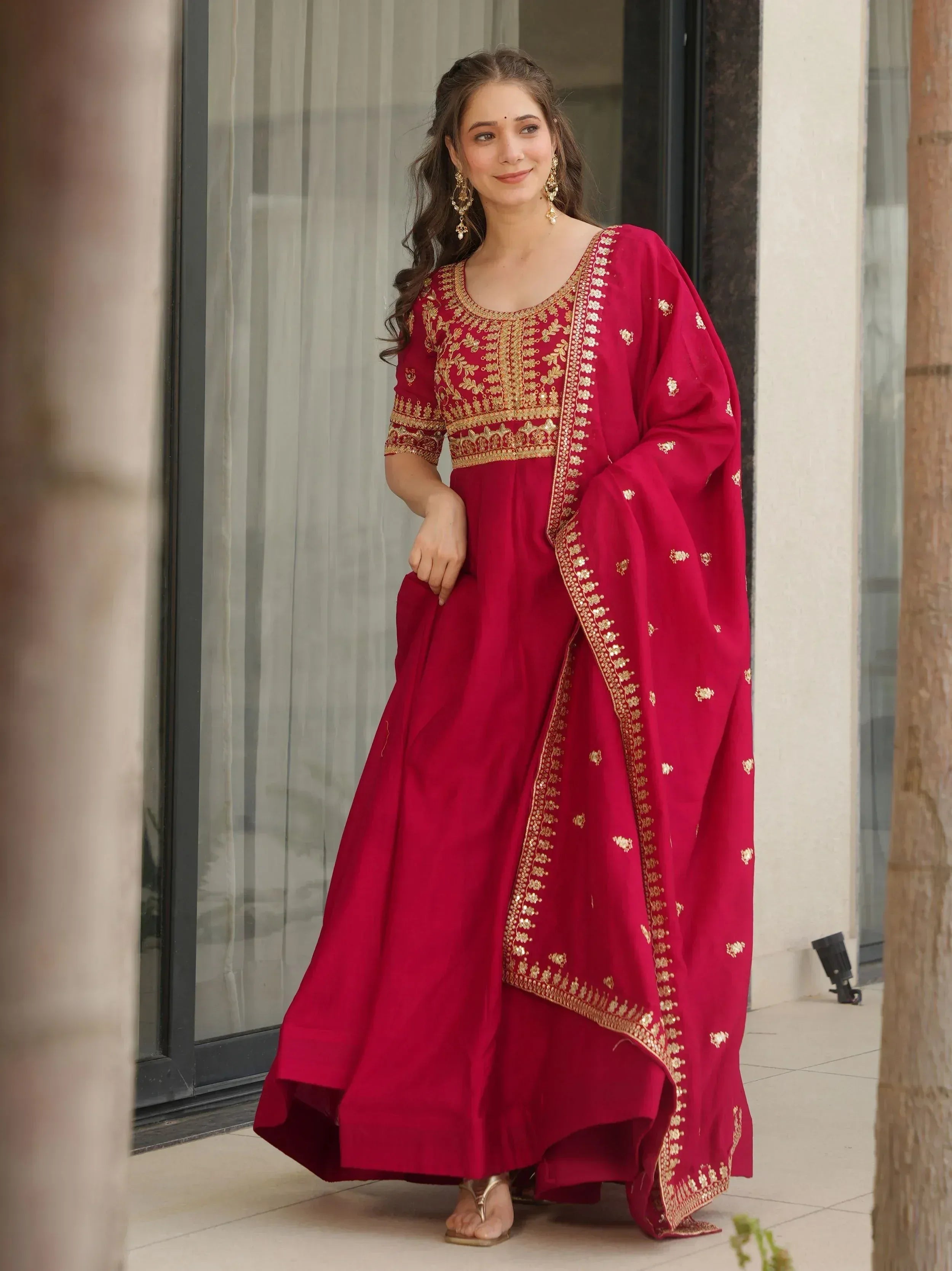 Red ethnic anarkali suit with gold embroidery, perfect for Indian festive occasions and weddings.