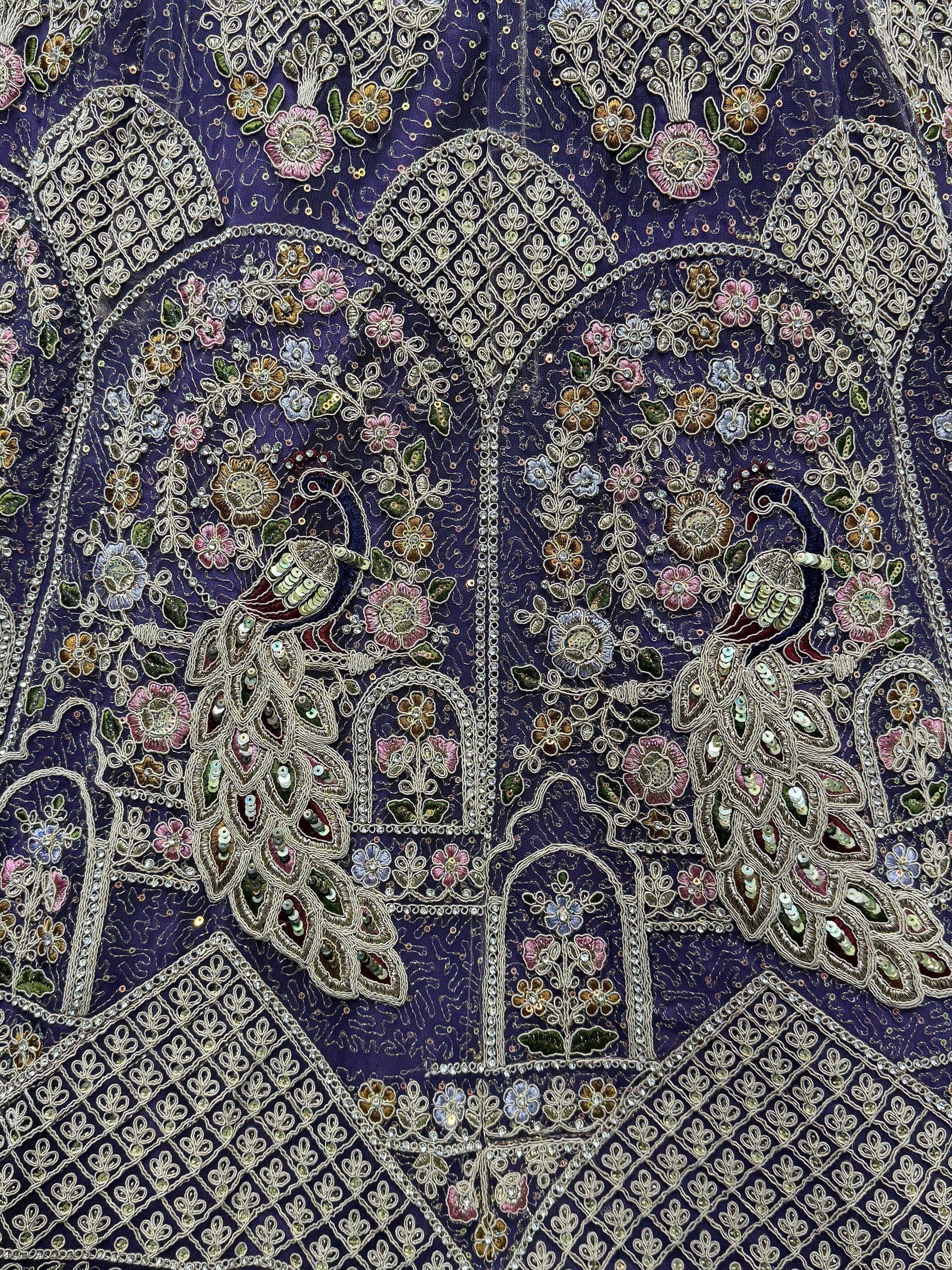 Purple ethnic wear with intricate floral embroidery, sequins, and peacock motifs for festive occasions