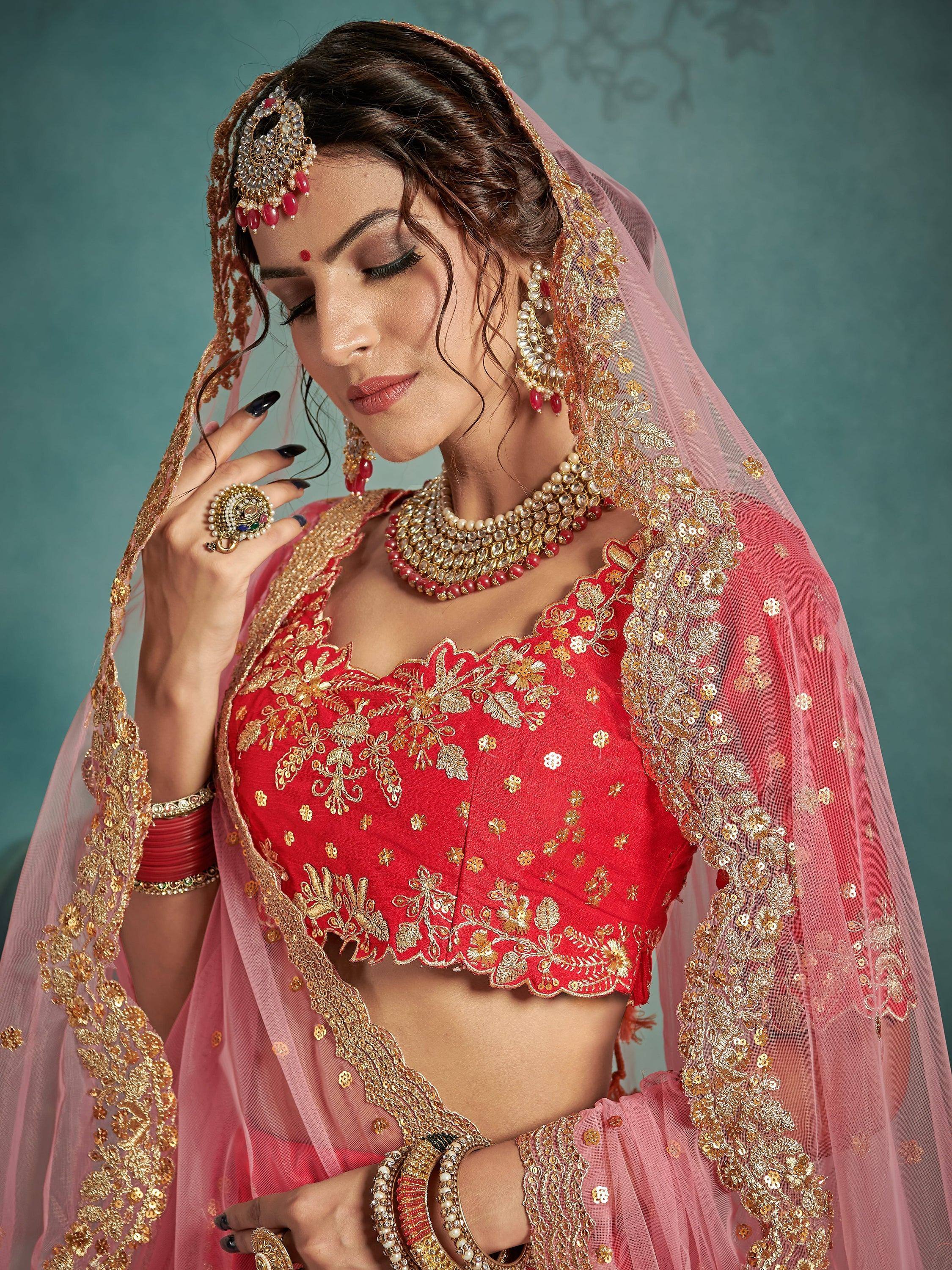 Red and gold embroidered lehenga choli with matching dupatta and traditional Indian bridal jewelry