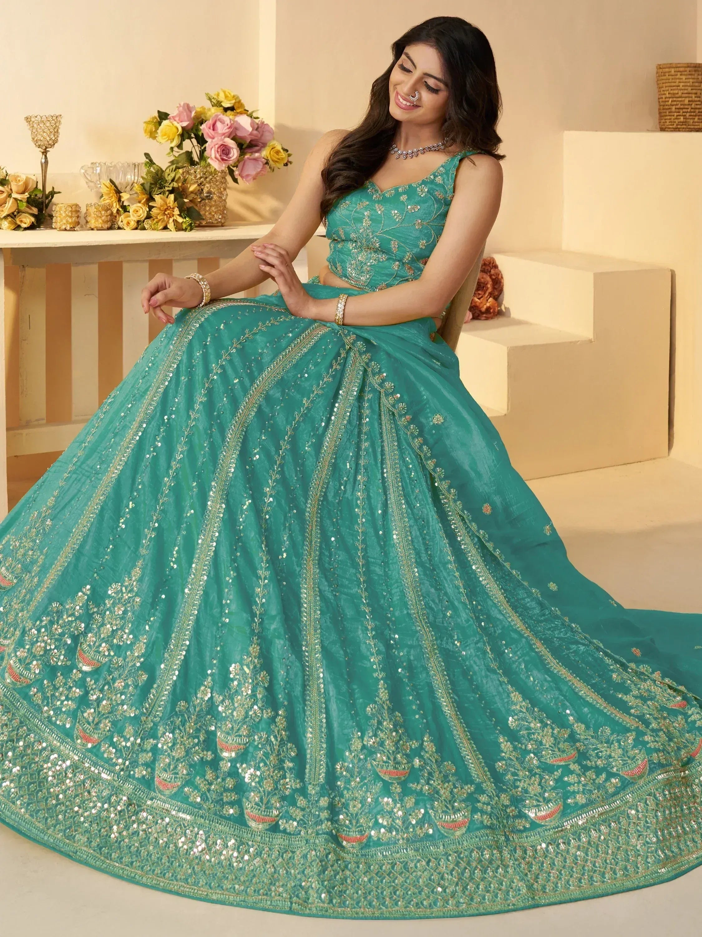 Teal designer lehenga choli with intricate gold embroidery and sequins, perfect for Indian weddings and festive occasions