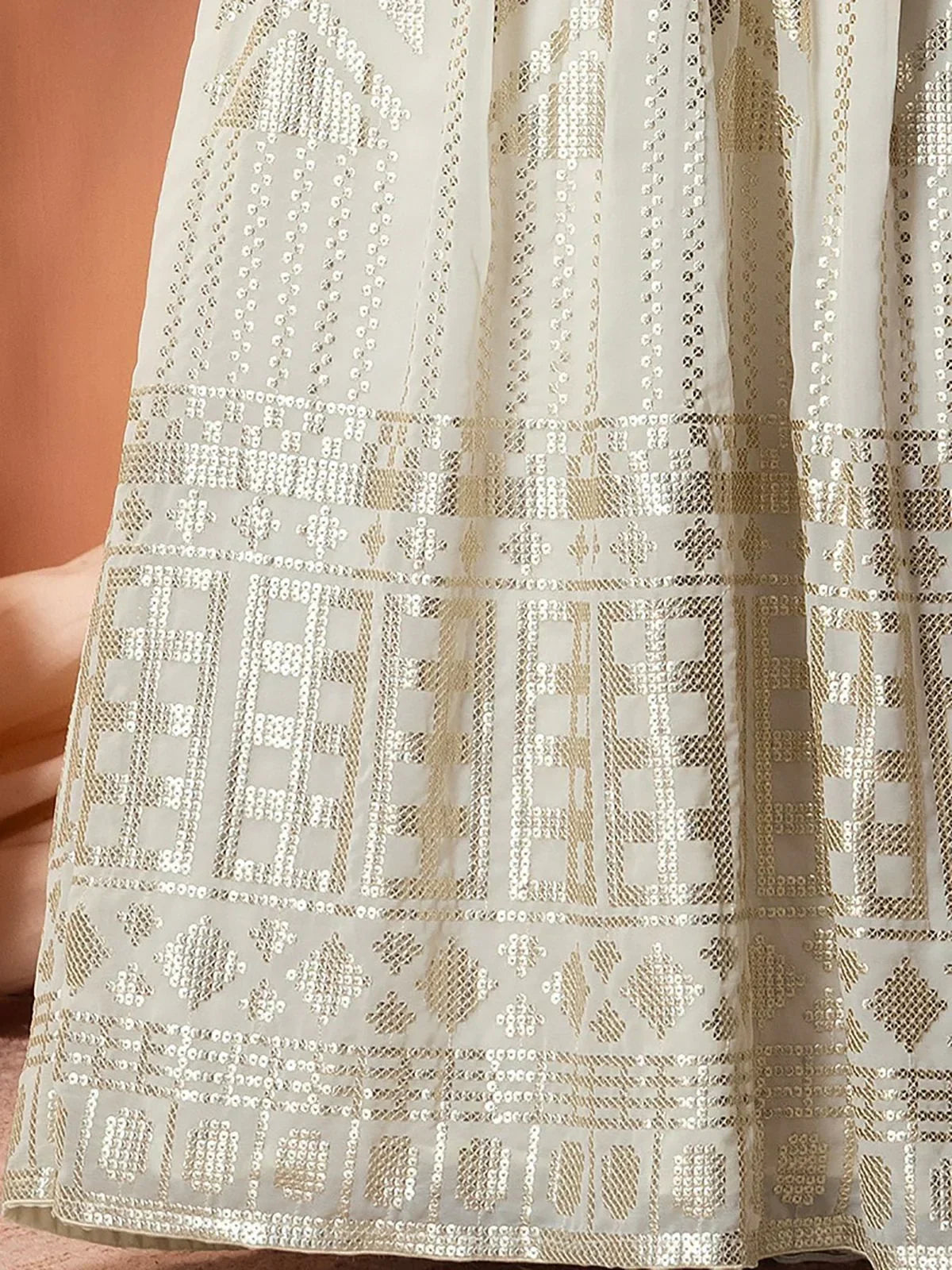 White ethnic gown with gold geometric embroidery and sequin detailing, perfect for Indian festive wear.