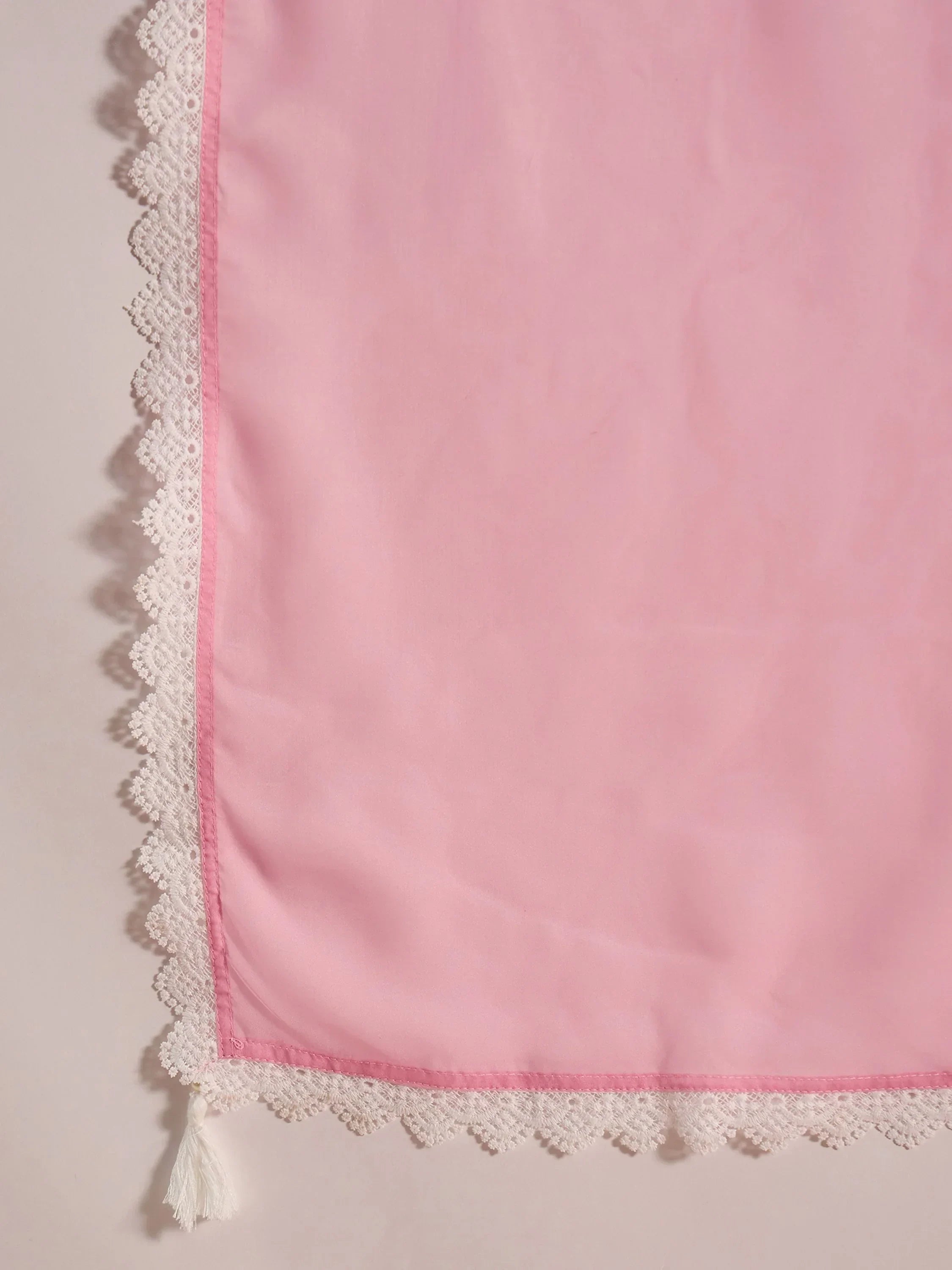 Light pink saree fabric with white lace border and decorative tassel corner