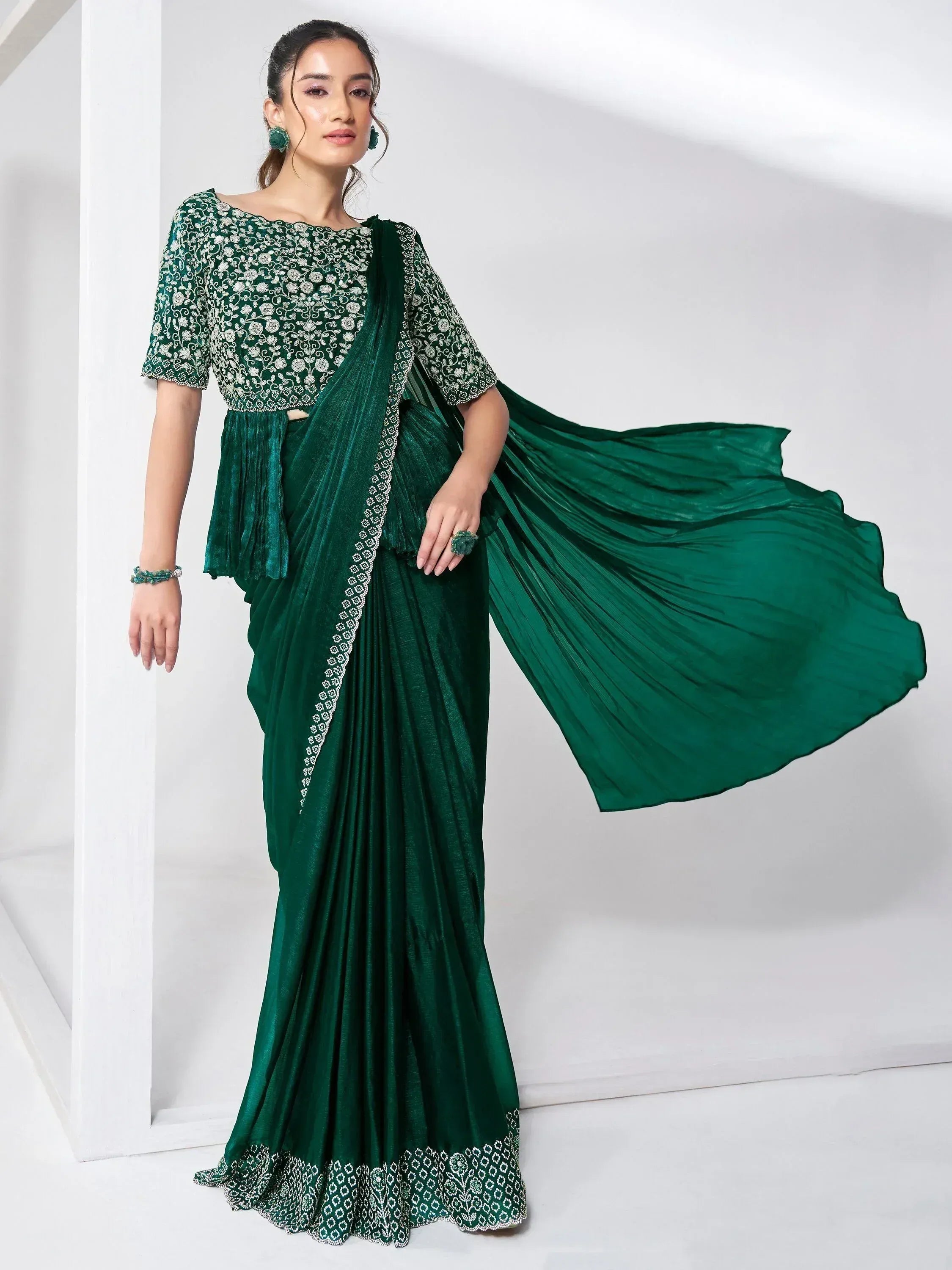 Emerald green designer saree with floral embroidery and pleated drape, perfect for ethnic occasions.