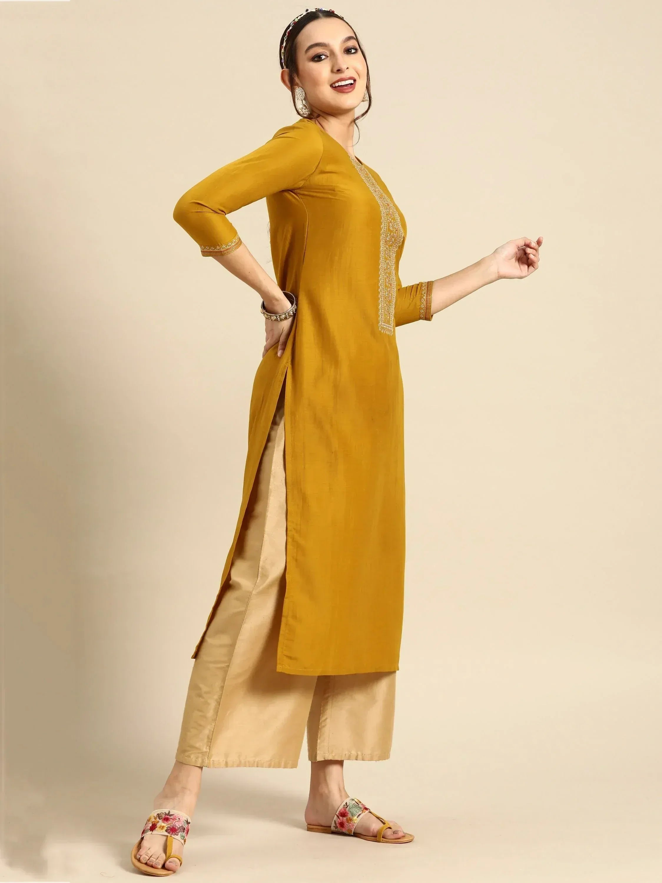Mustard yellow ethnic kurta with gold embroidery, paired with palazzo pants and floral sandals