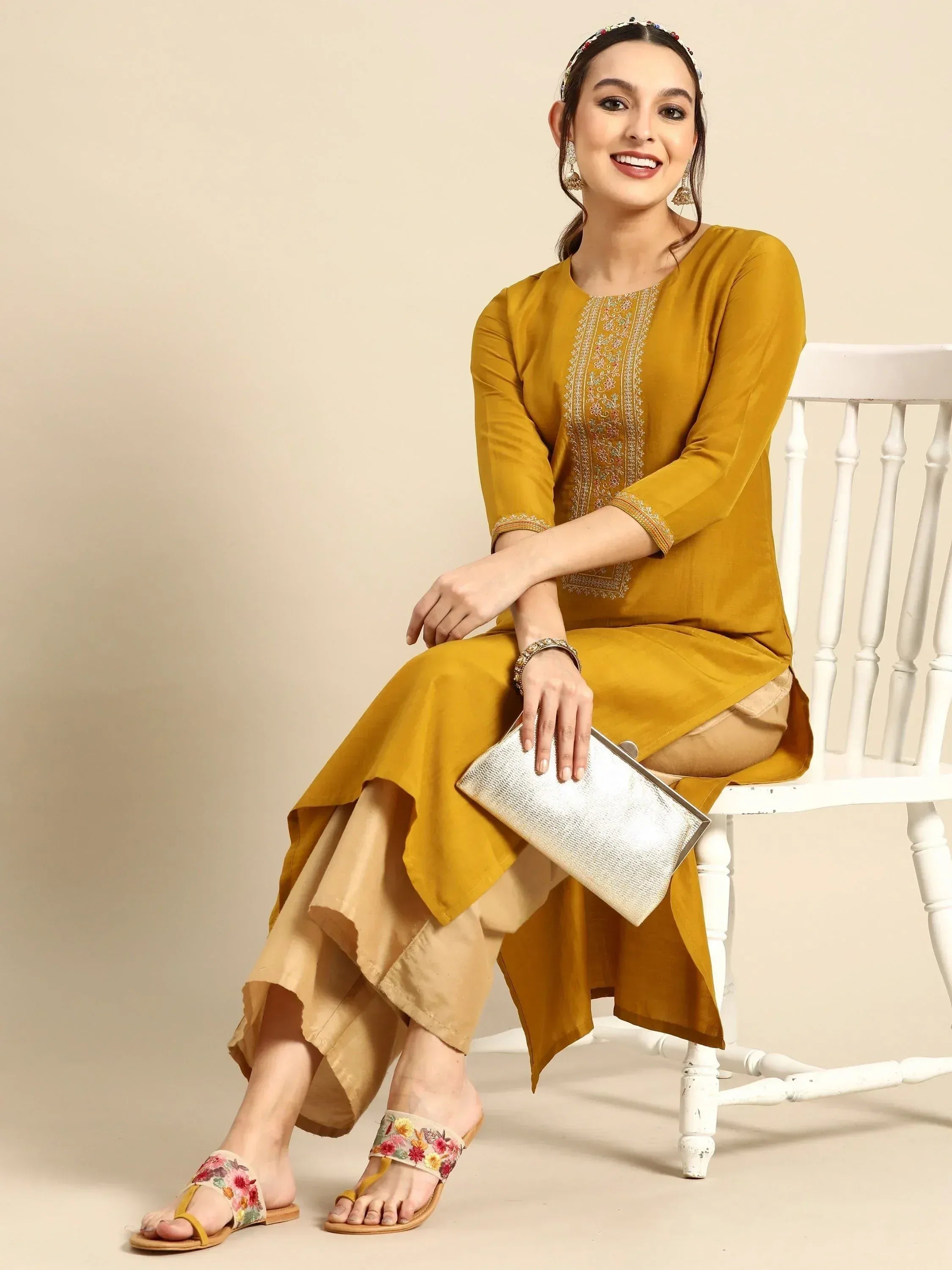 Mustard yellow embroidered kurta with palazzo pants, floral sandals, and silver clutch for ethnic wear