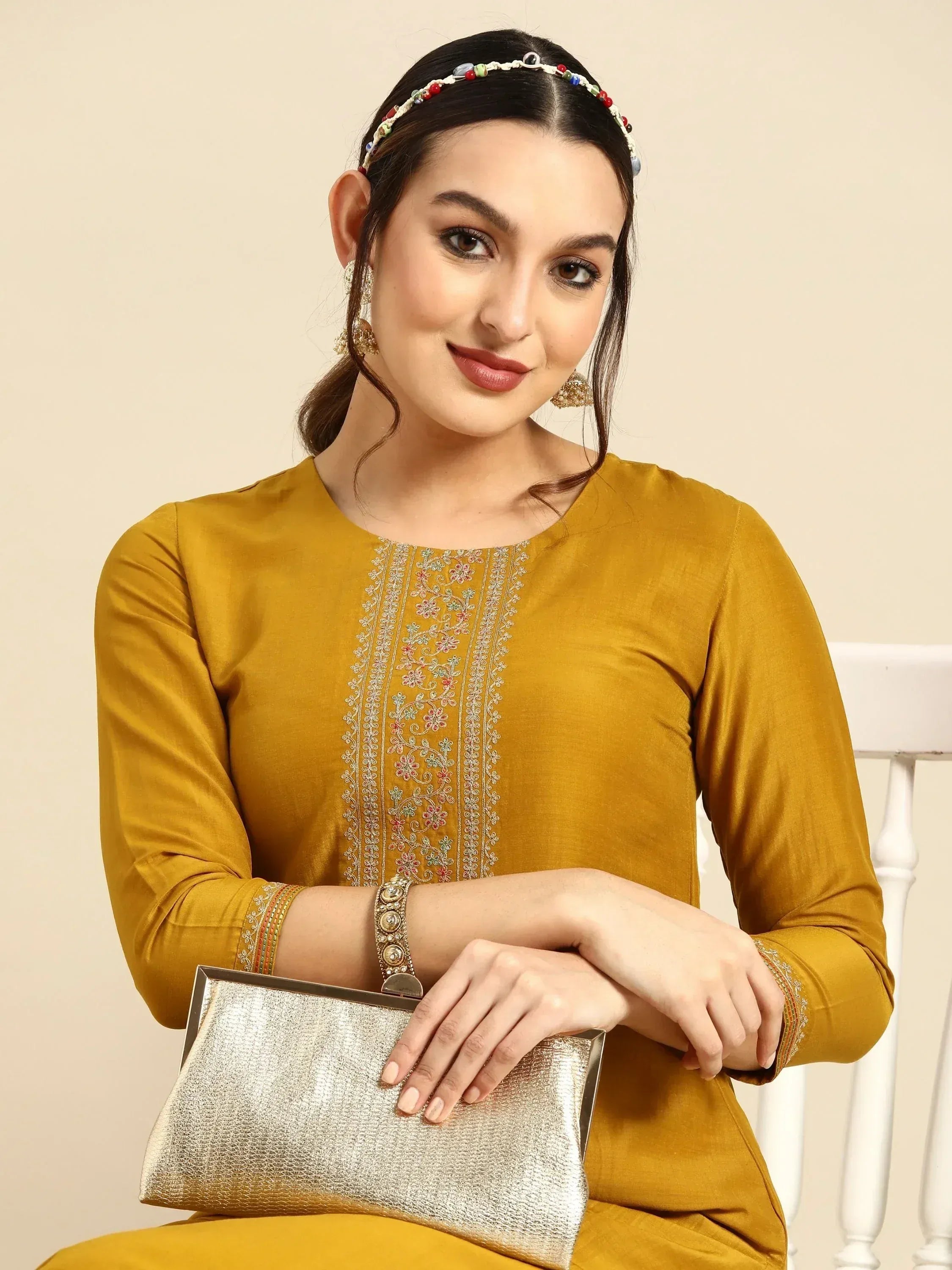 Mustard yellow embroidered kurti with floral detailing, paired with beaded headband and gold clutch for ethnic wear