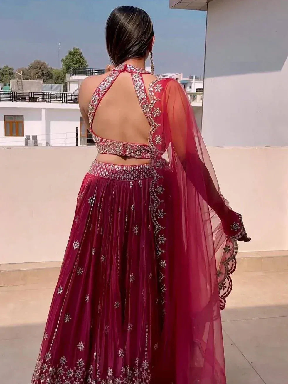 Back view of woman in maroon embroidered lehenga choli with sheer dupatta, perfect for Indian ethnic occasions
