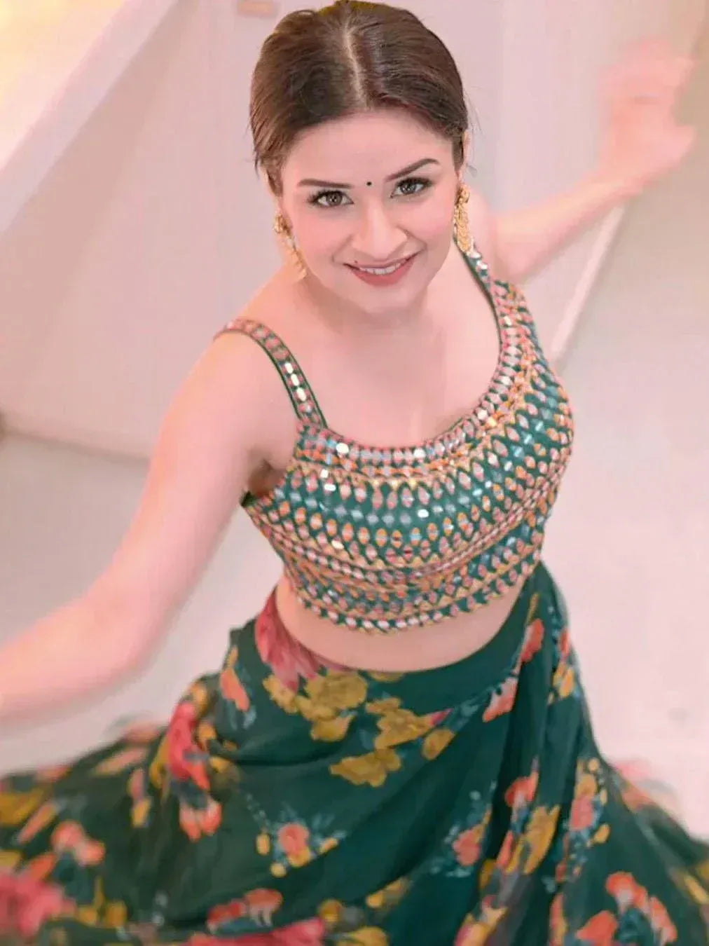 Woman in green floral lehenga choli with mirror work, perfect for Indian ethnic wear occasions