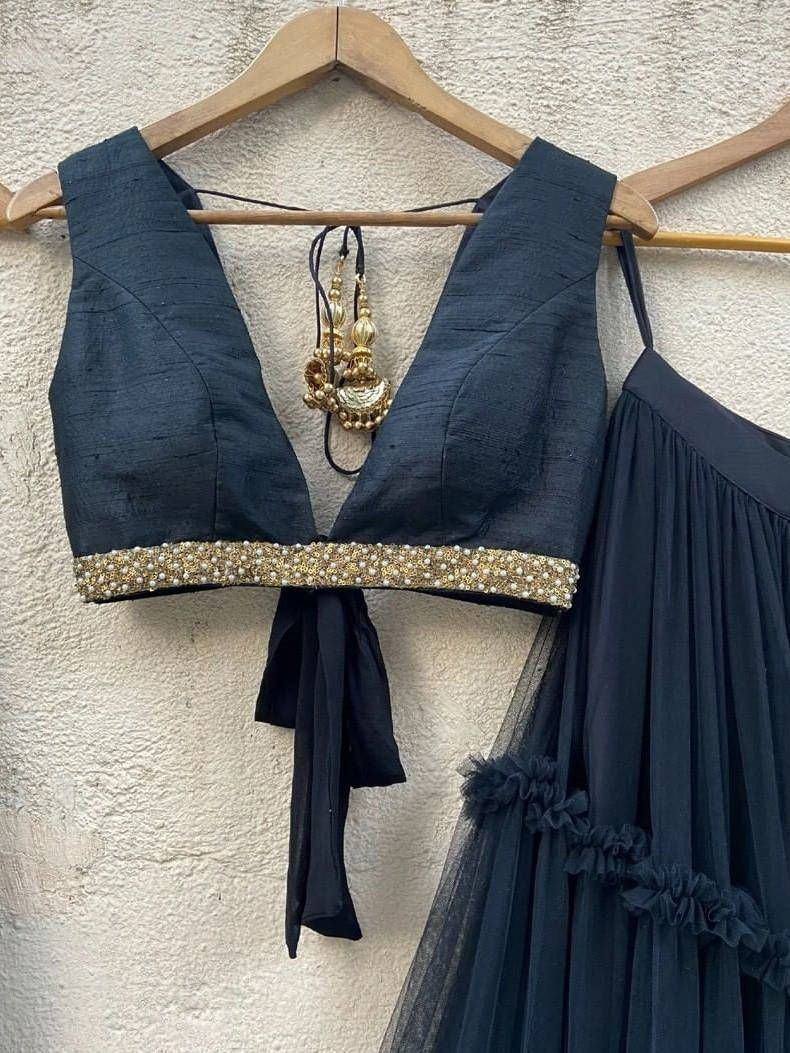 Dark blue designer lehenga choli with gold bead border and ruffled skirt, paired with traditional earrings