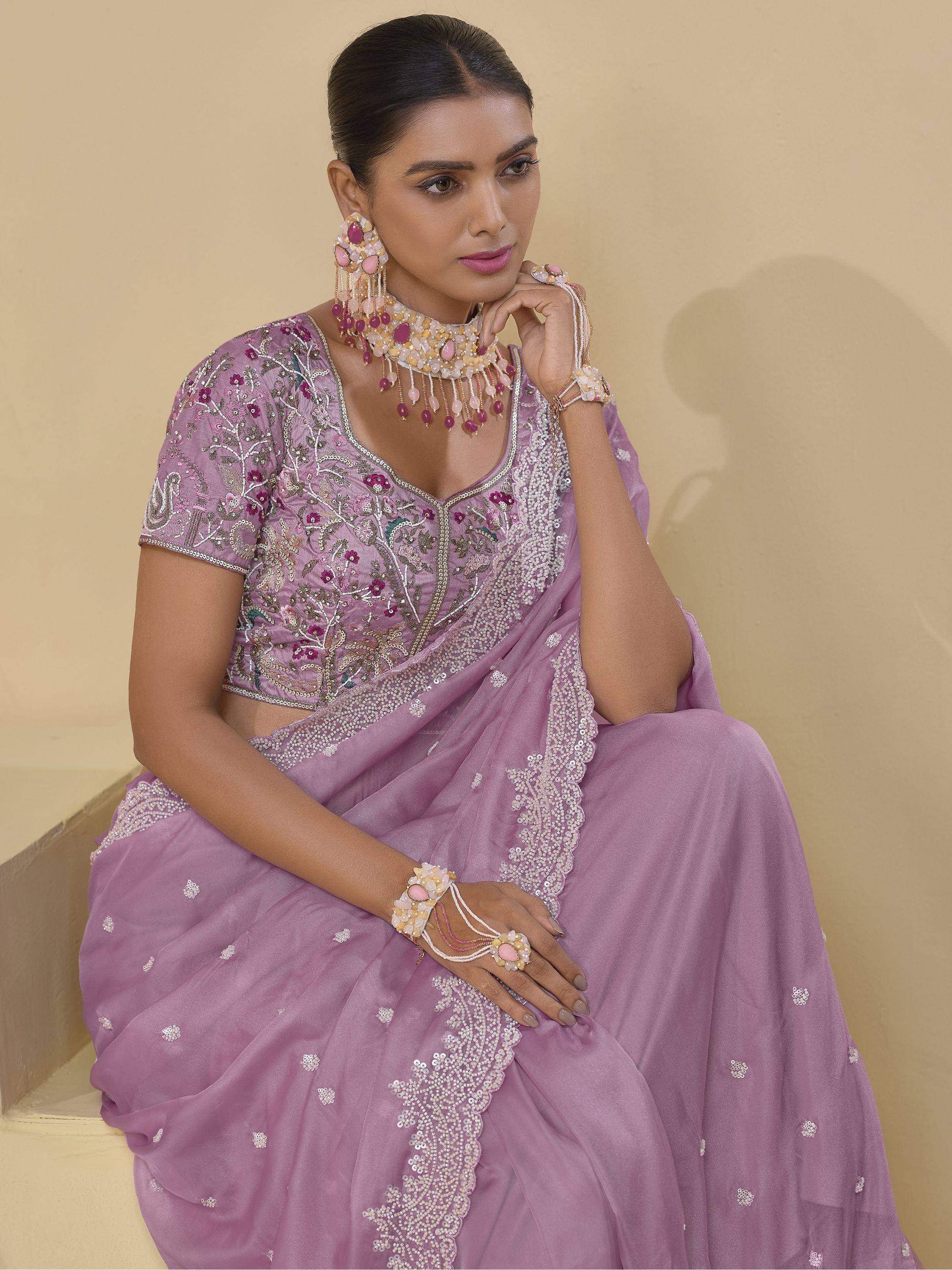 Lavender embroidered saree with floral motifs, paired with matching jewelry for Indian ethnic wear.