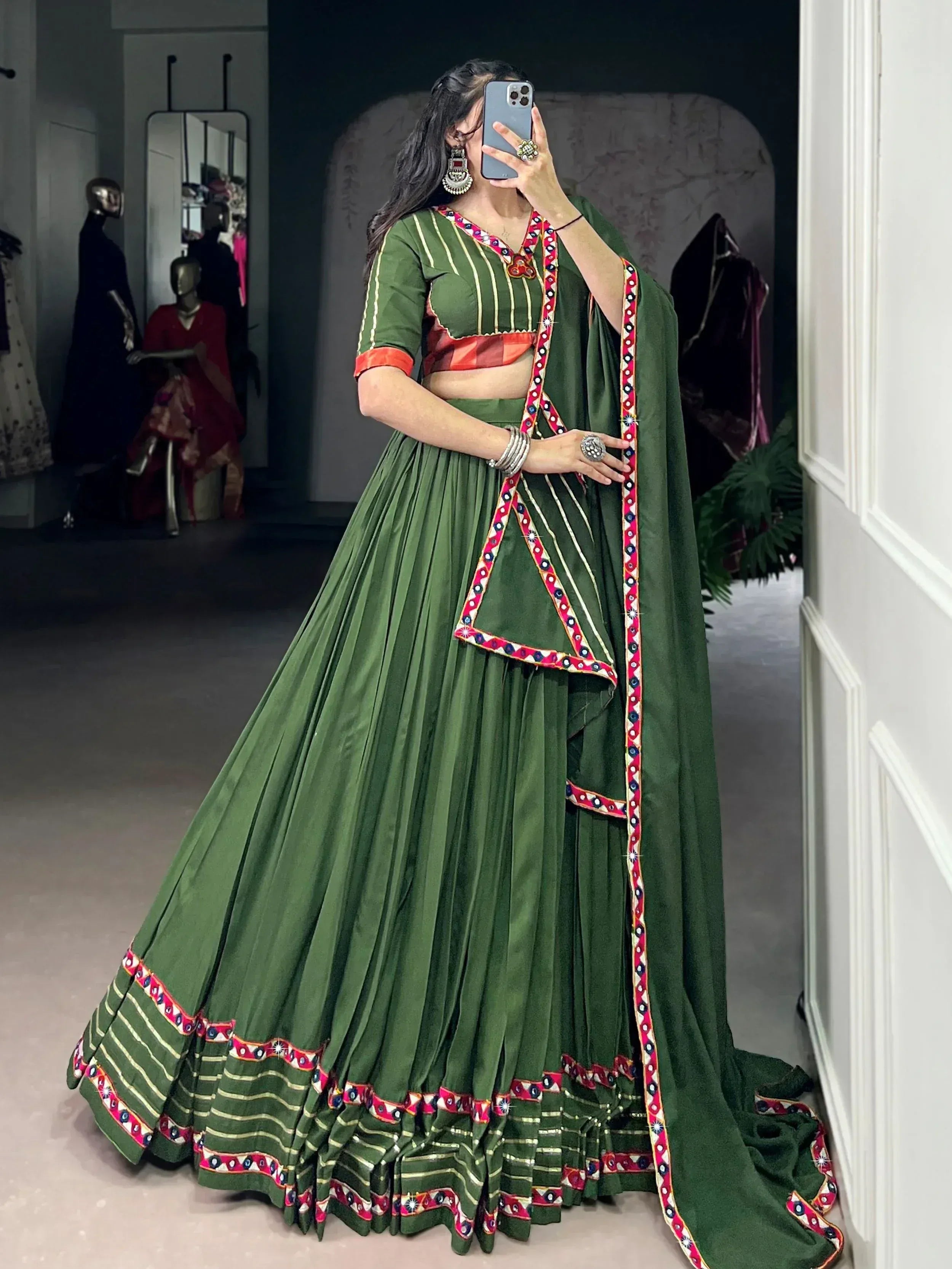 Green ethnic lehenga choli with mirror work and red border, perfect for Indian weddings and festivals