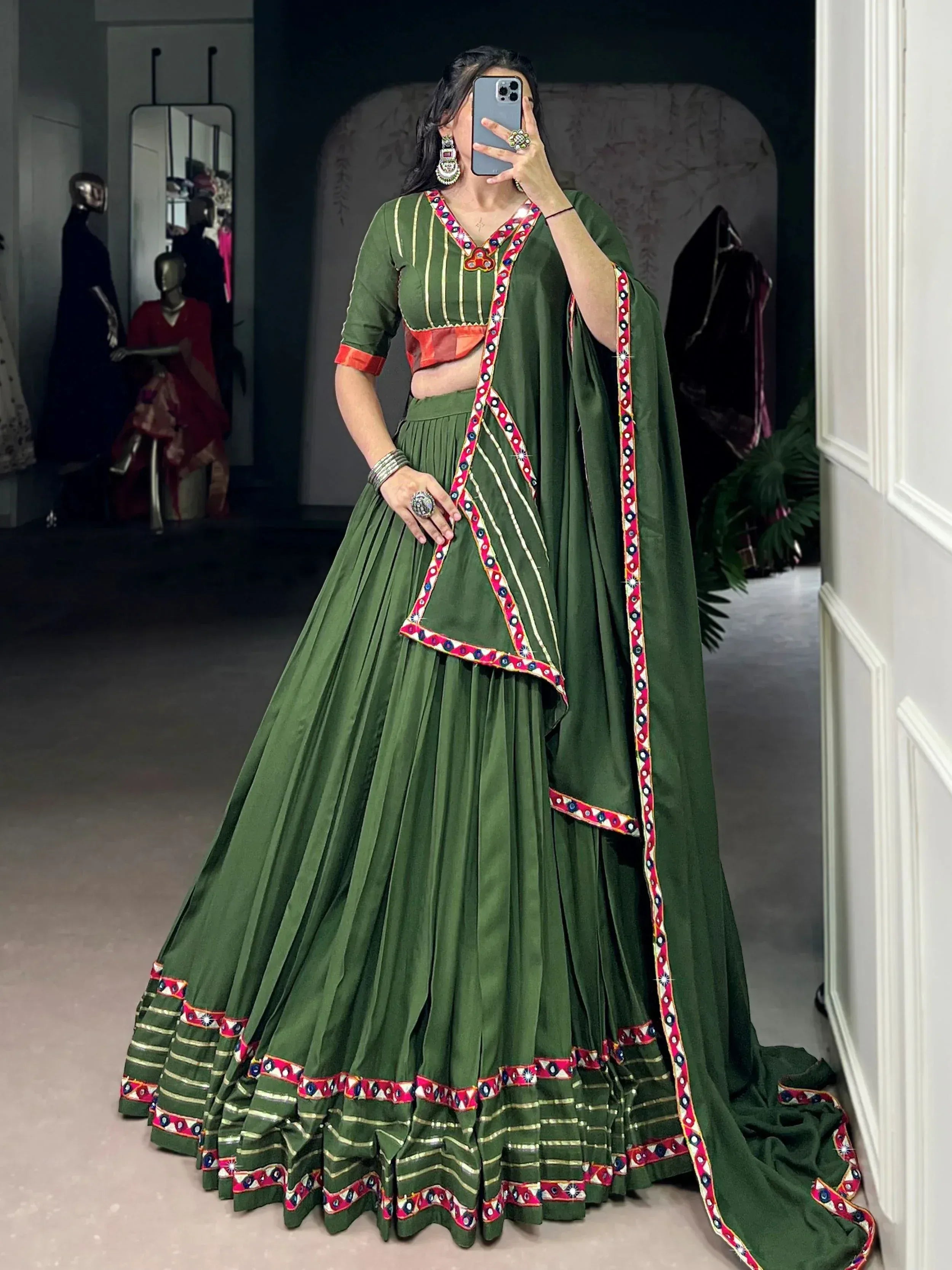 Green ethnic lehenga choli with mirror work and red border, perfect for Indian weddings or festivals