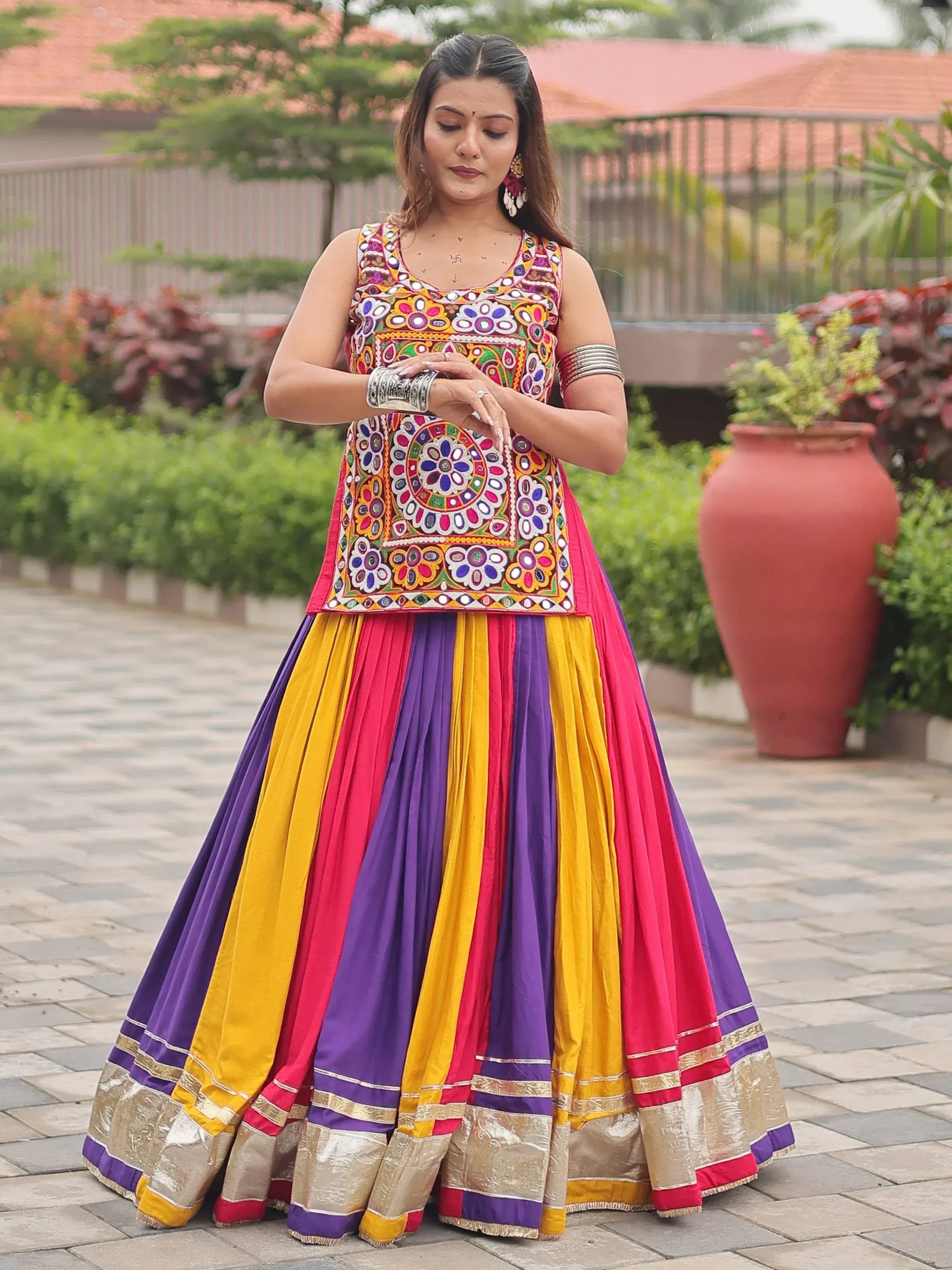 Colorful embroidered Indian lehenga choli with mirror work and striped skirt, perfect for festive occasions