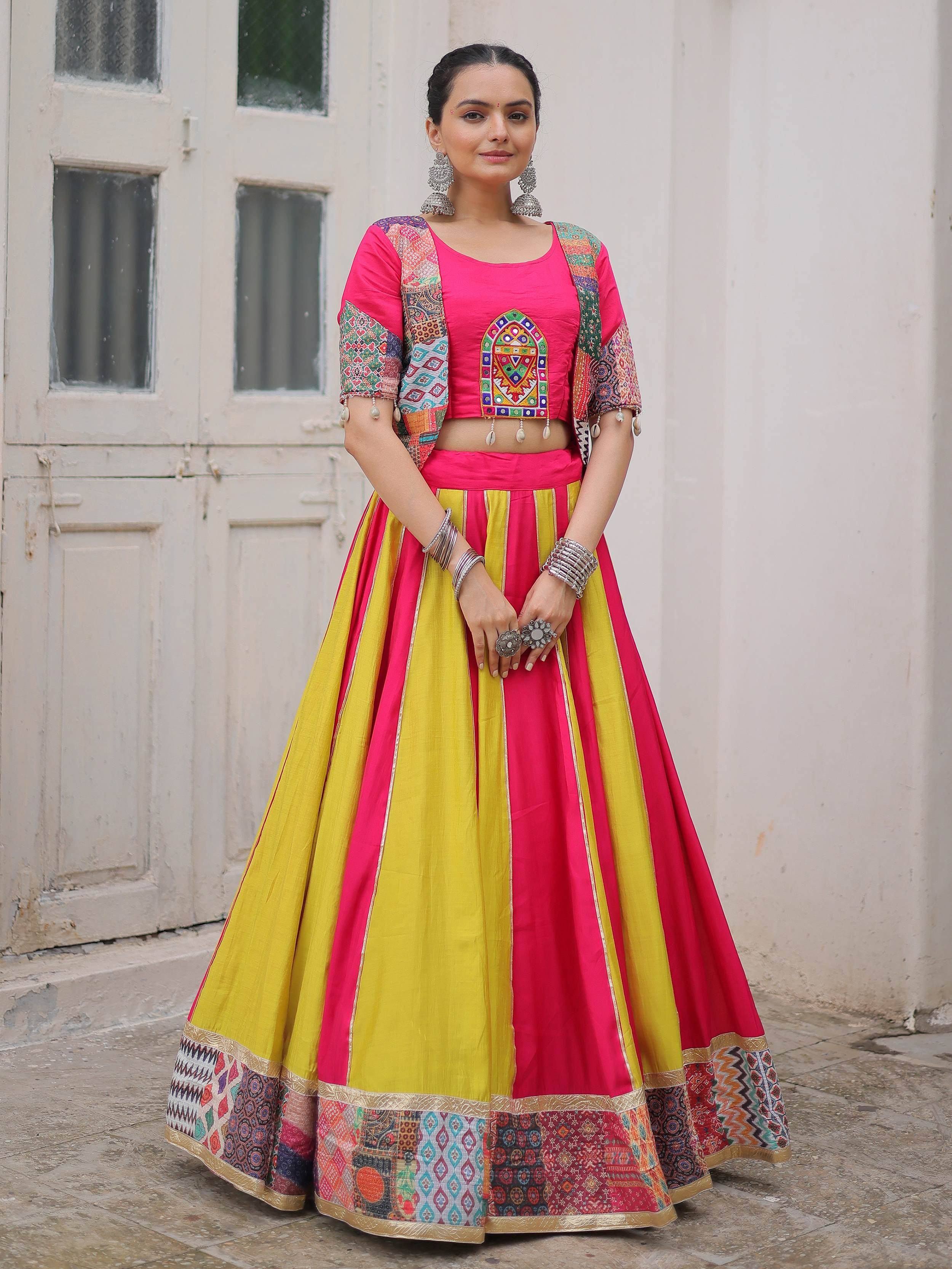 Vibrant pink and yellow lehenga choli with colorful patchwork and mirror embroidery, perfect for Indian ethnic wear.