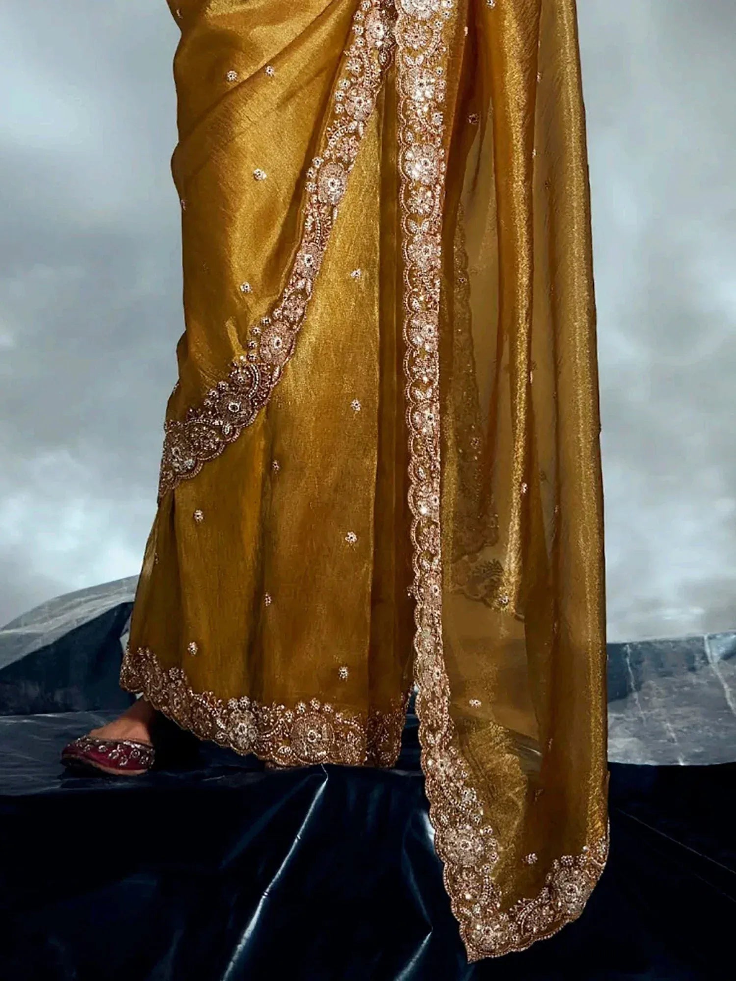 Golden ethnic saree with intricate embroidery and embellished border, perfect for Indian weddings and festivals