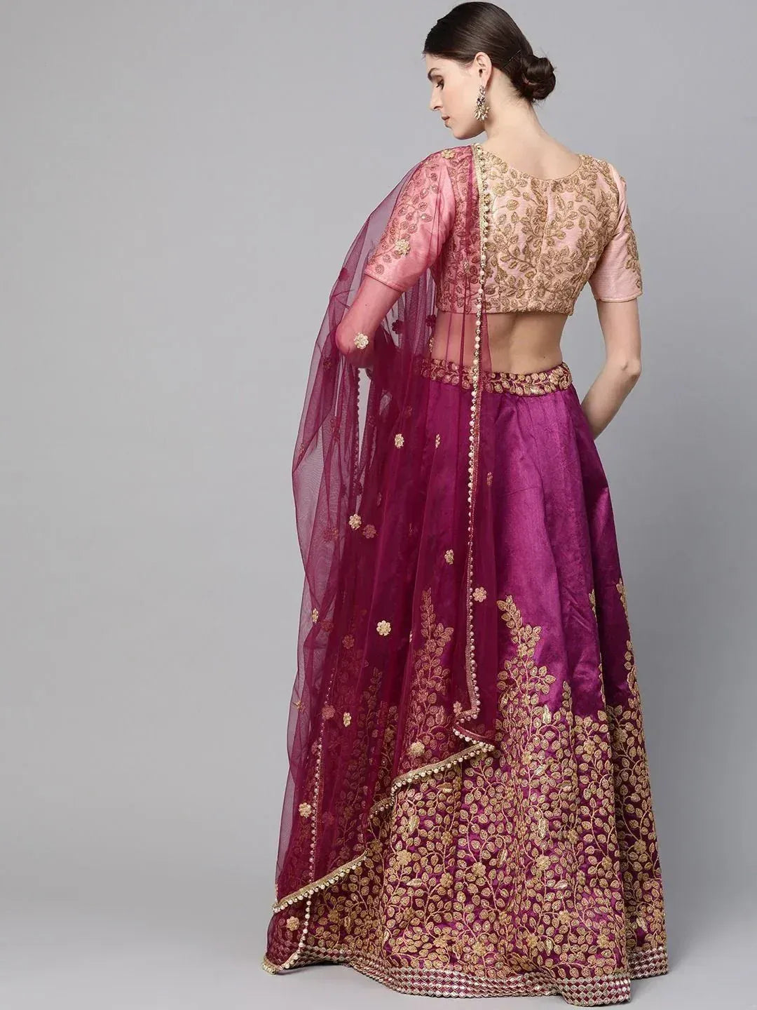 Elegant purple lehenga choli with gold embroidery and sheer dupatta, perfect for Indian weddings and festive occasions.