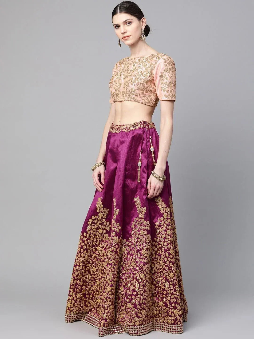 Elegant purple and gold embroidered lehenga choli with floral motifs, perfect for Indian ethnic occasions.
