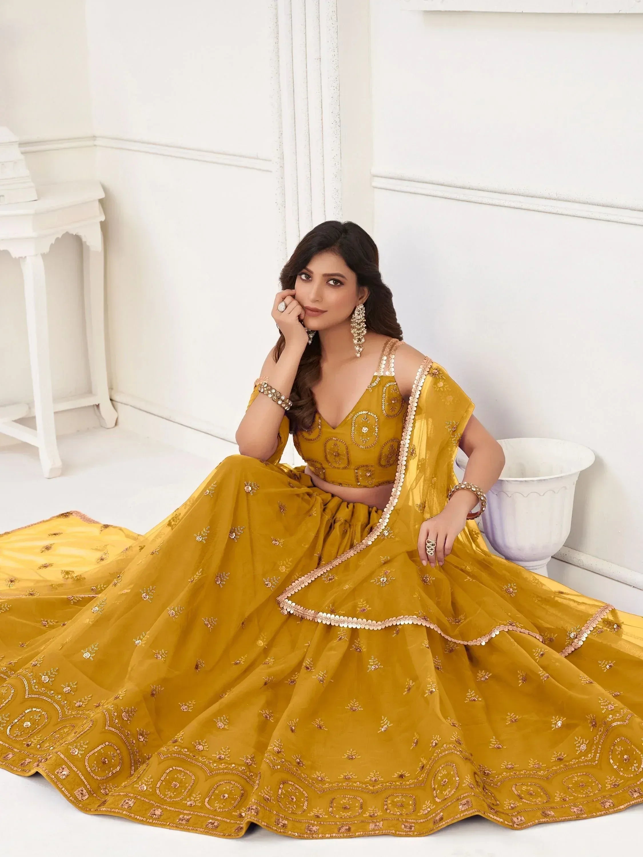 Mustard yellow designer lehenga choli with intricate embroidery and sequin detailing, perfect for Indian ethnic occasions.