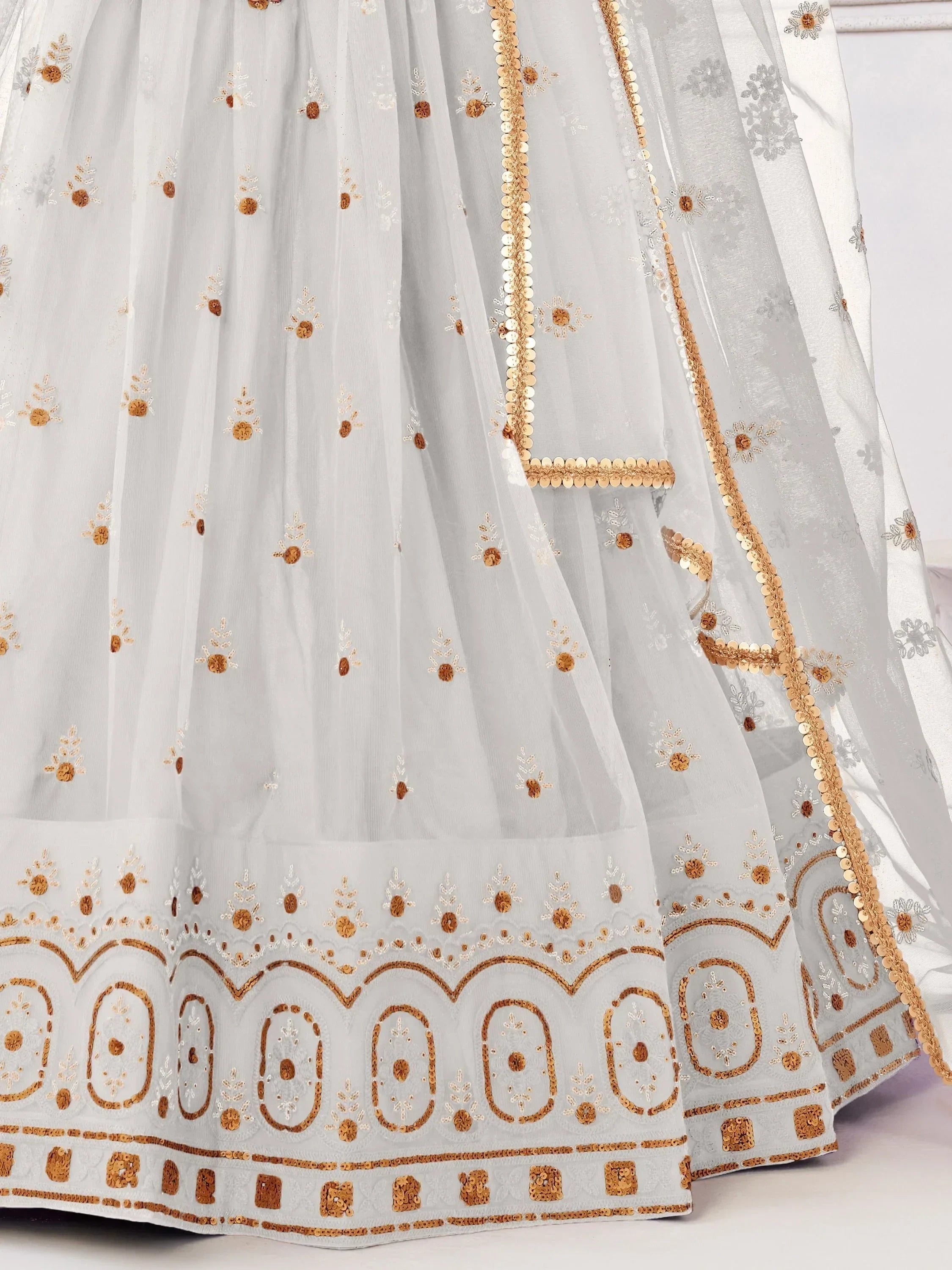 White ethnic lehenga with gold floral embroidery and sequin detailing, perfect for Indian weddings and festivals