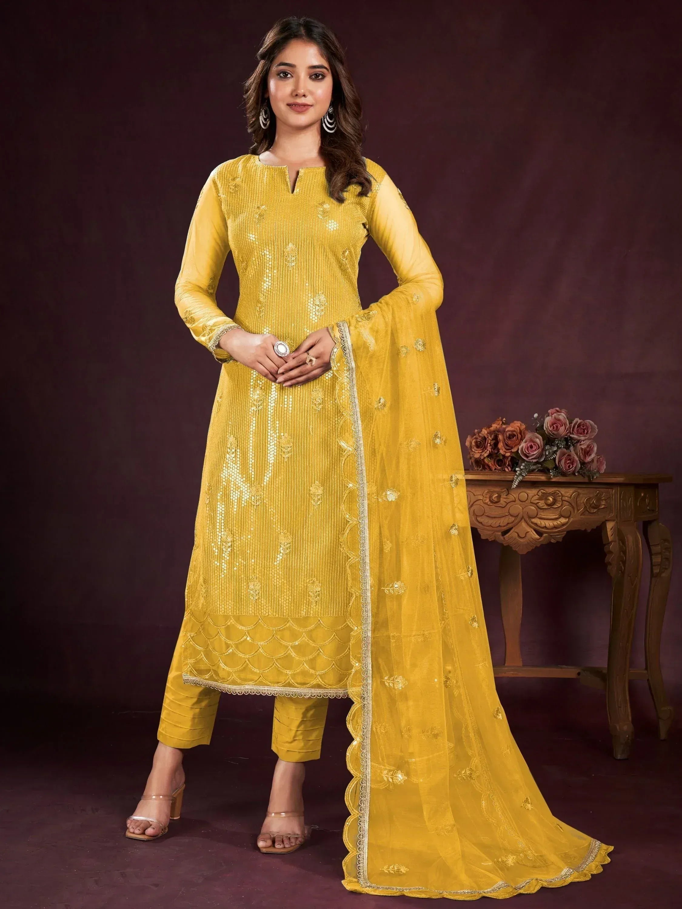 Yellow designer salwar kameez with embroidery and scalloped hem, paired with matching dupatta.