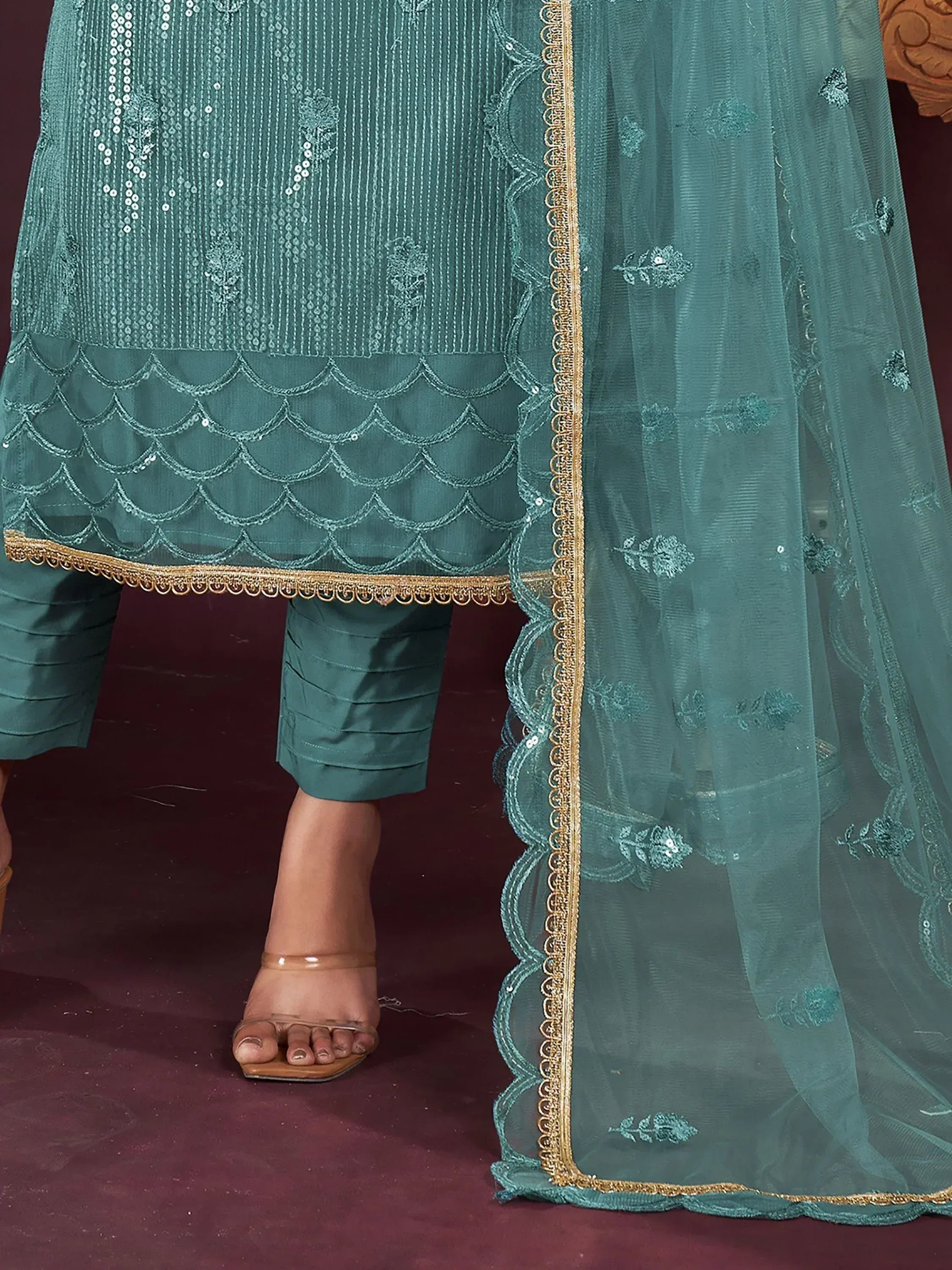 Teal ethnic salwar kameez with scalloped embroidery and gold trim, paired with sheer dupatta