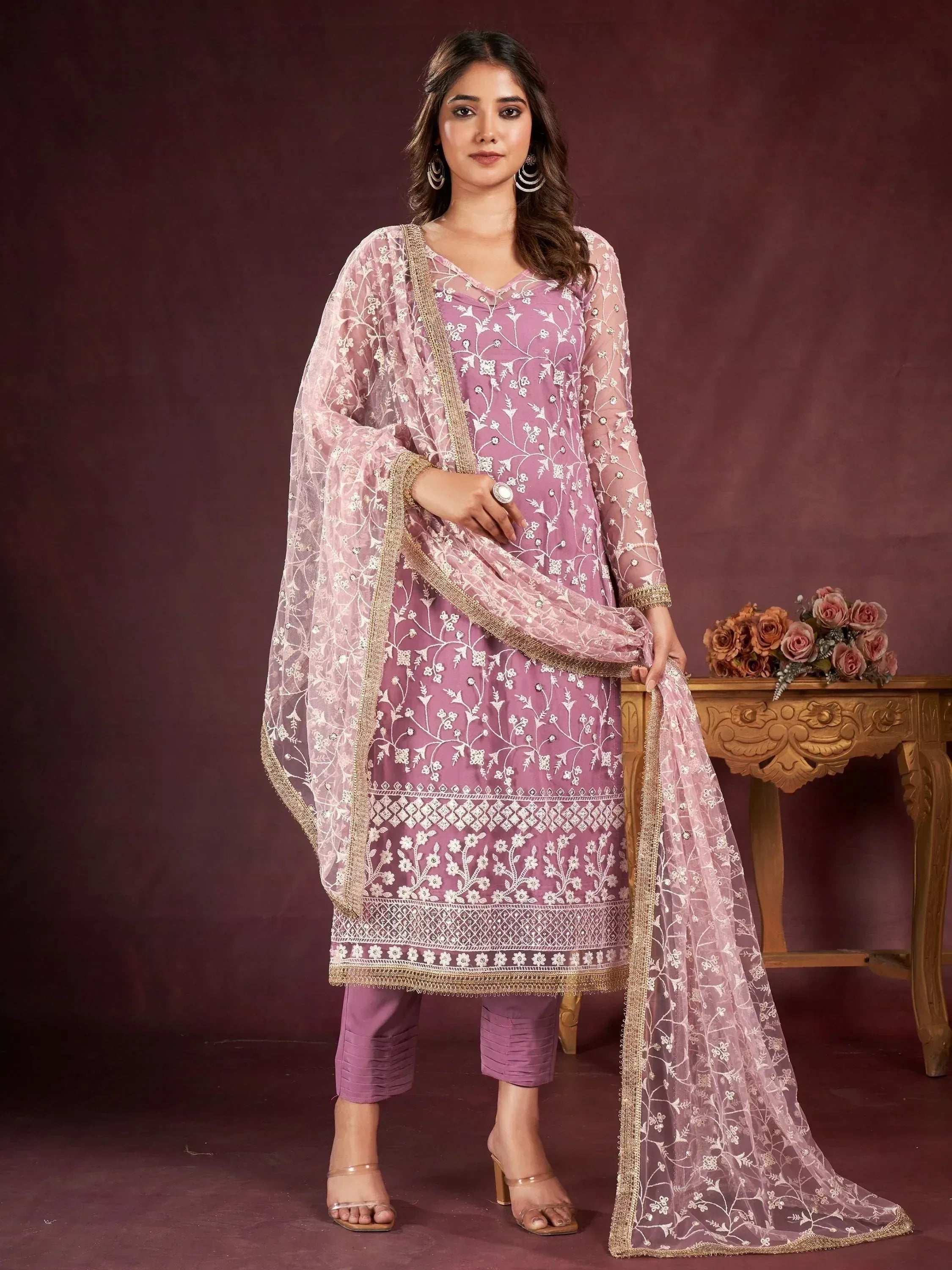Elegant purple embroidered salwar kameez with floral detailing and gold trim, perfect for festive occasions.
