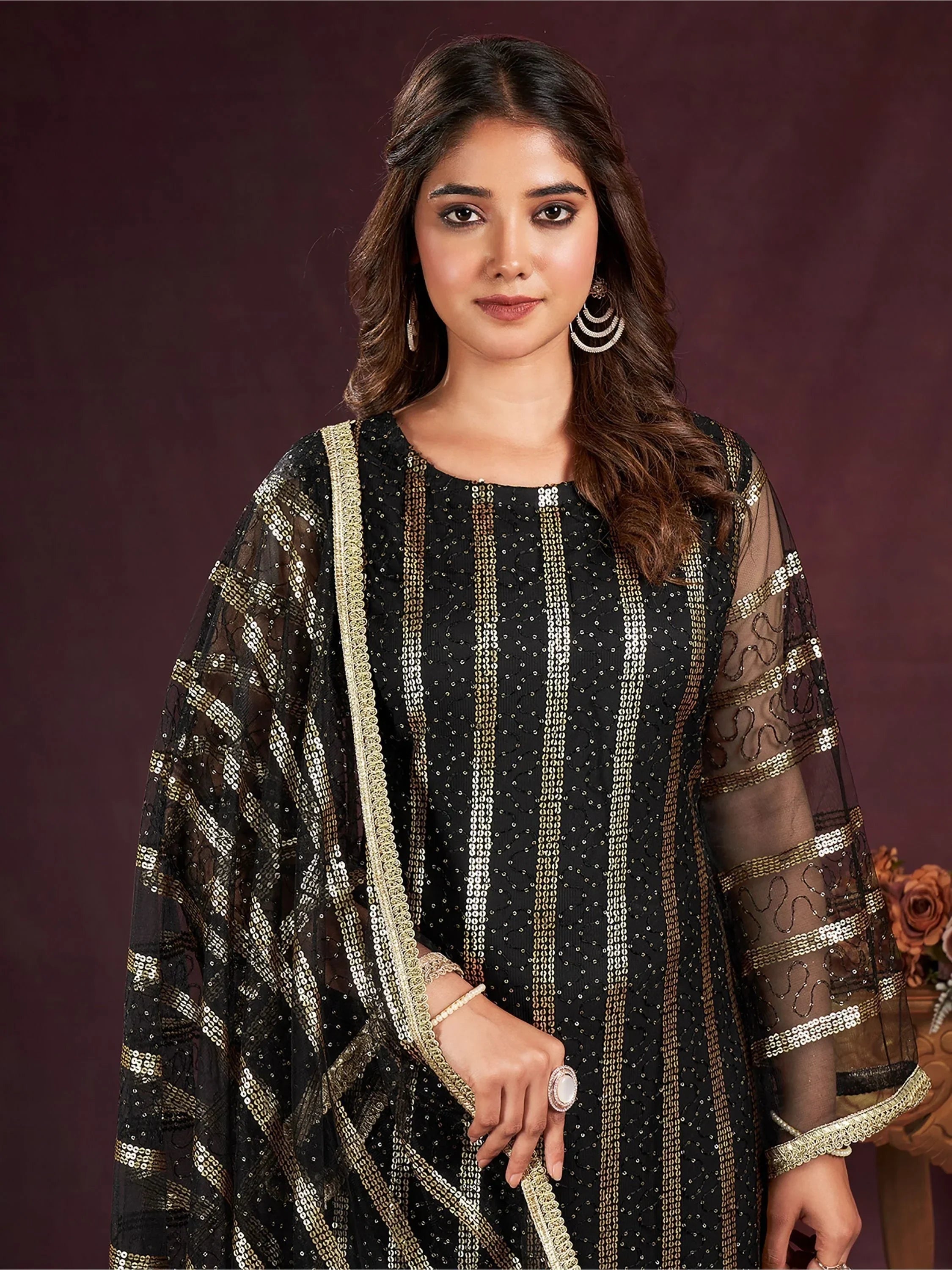 Woman wearing black and gold sequin embroidered ethnic gown with sheer dupatta