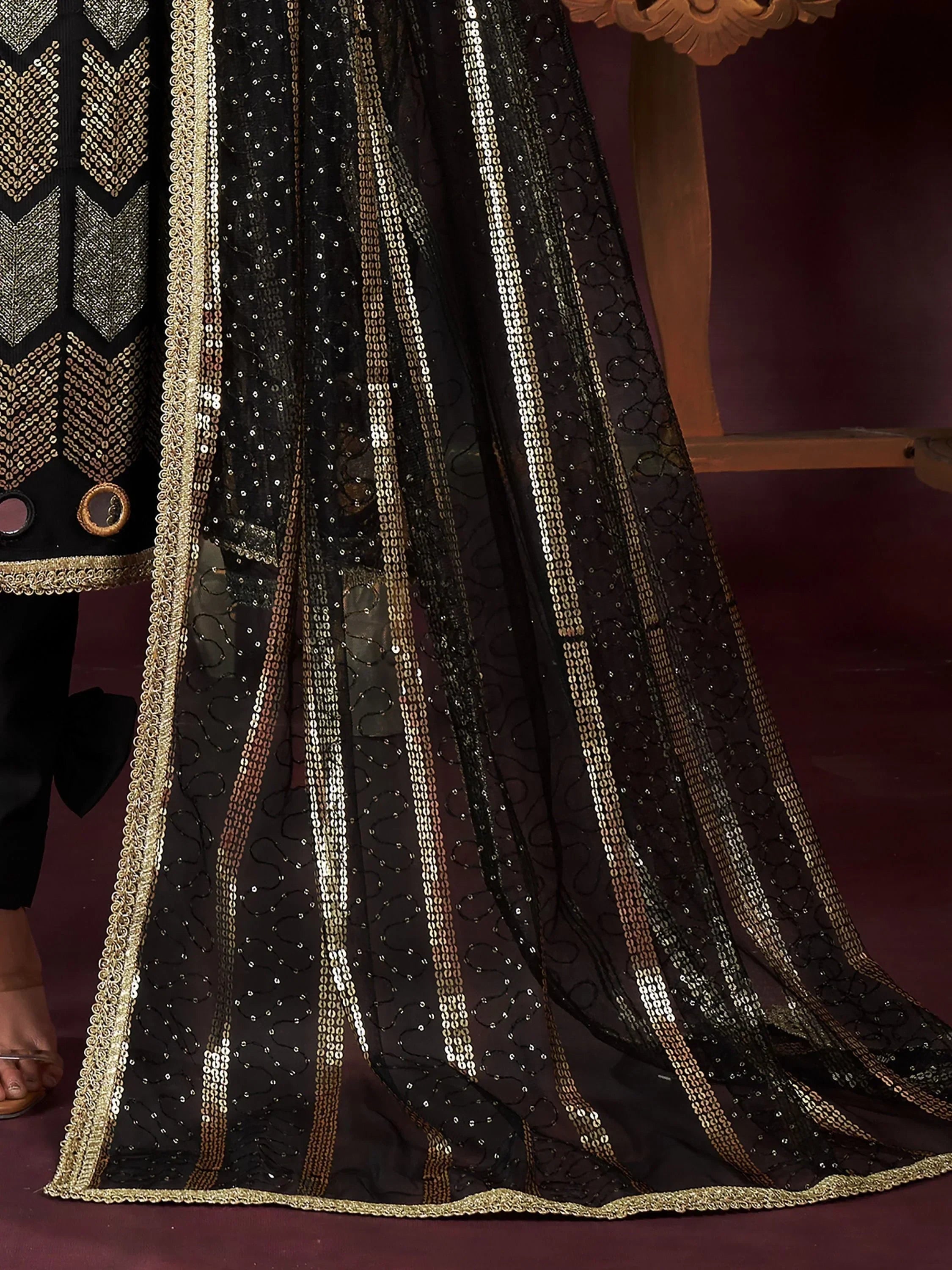 Black net dupatta with gold sequin stripes and embroidery, paired with ethnic suit