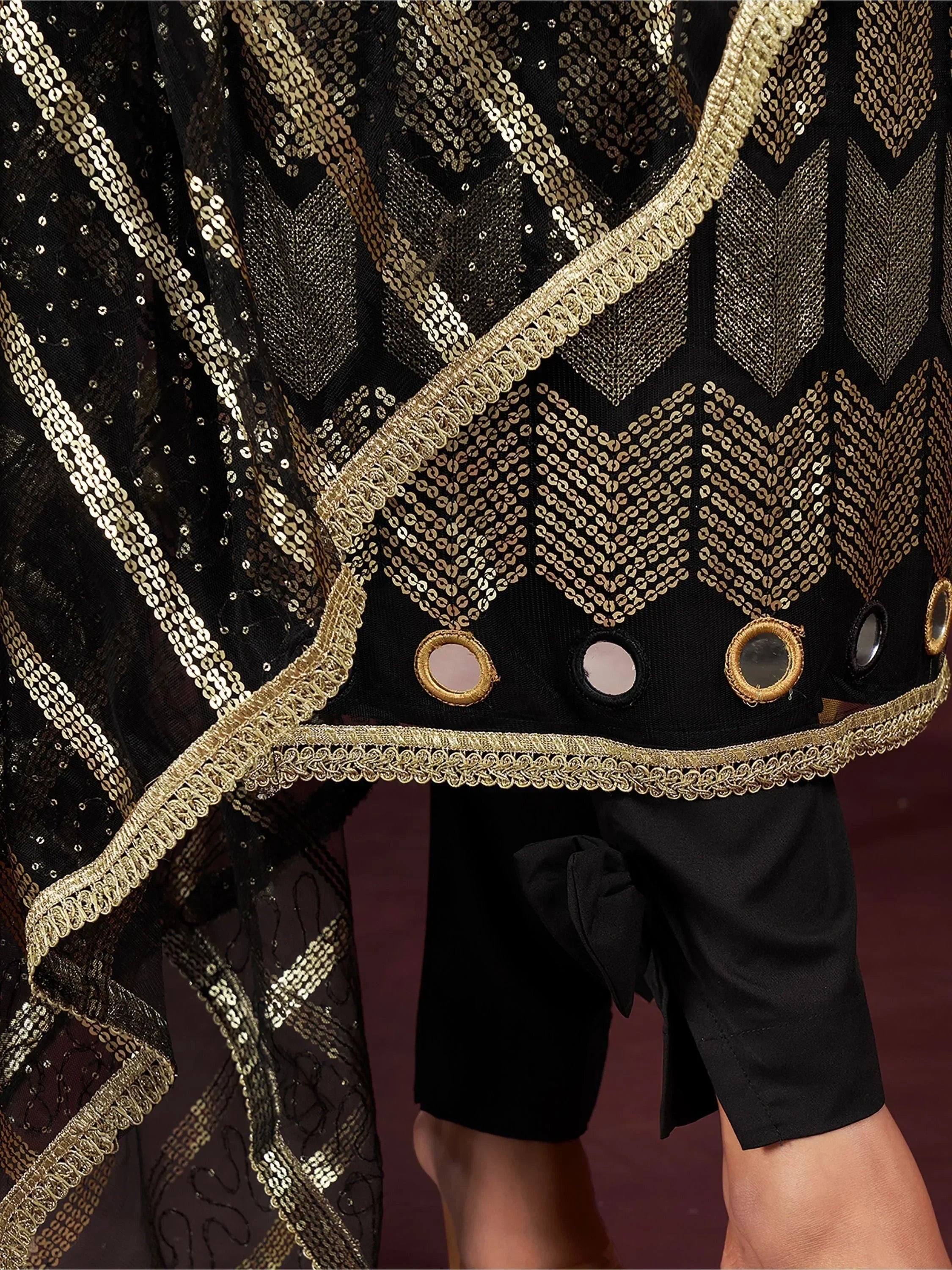 Black ethnic wear with gold sequin embroidery, mirror work, and intricate border detail
