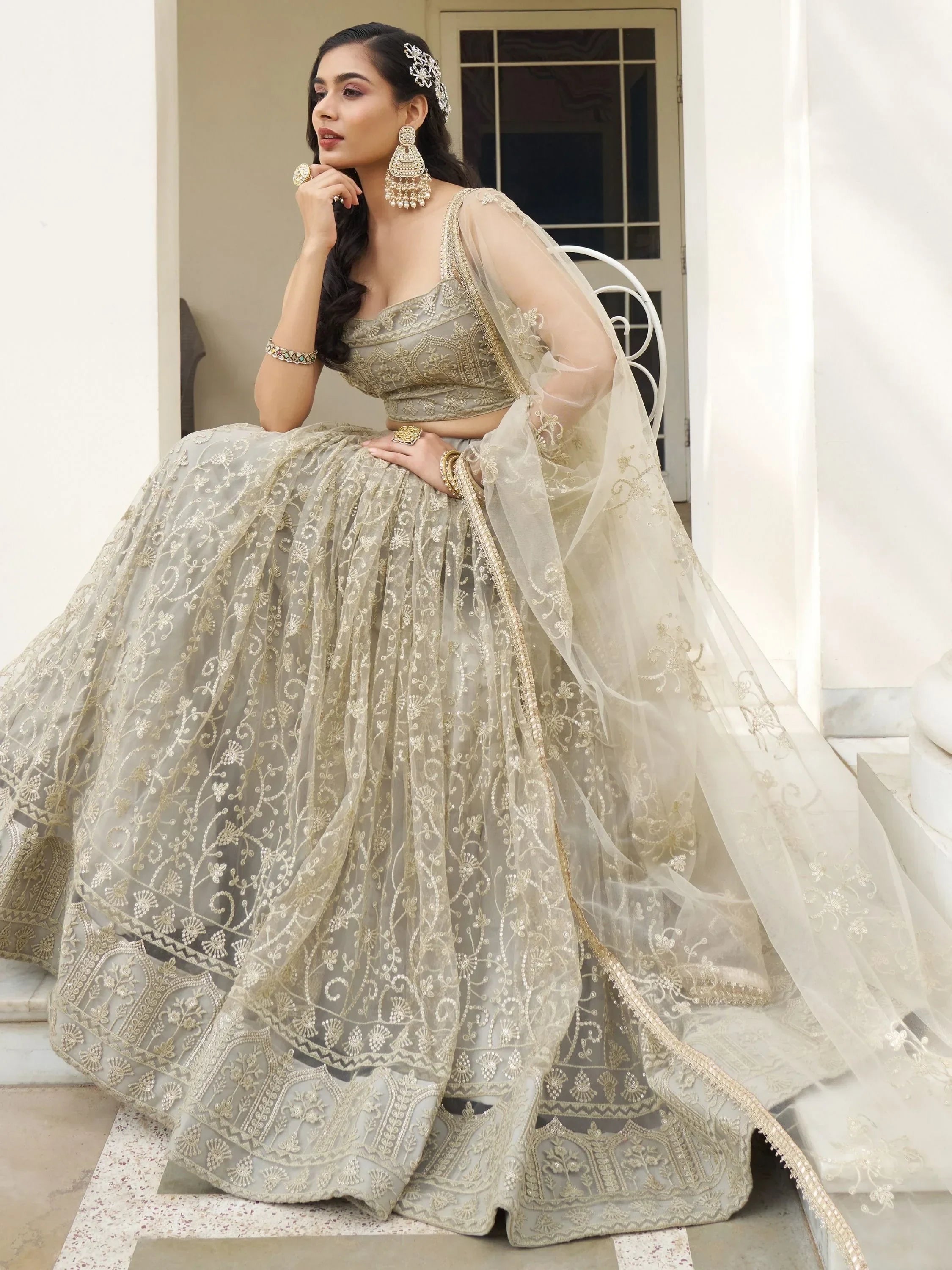 Elegant beige embroidered lehenga choli with sheer dupatta, perfect for Indian weddings and festive occasions.
