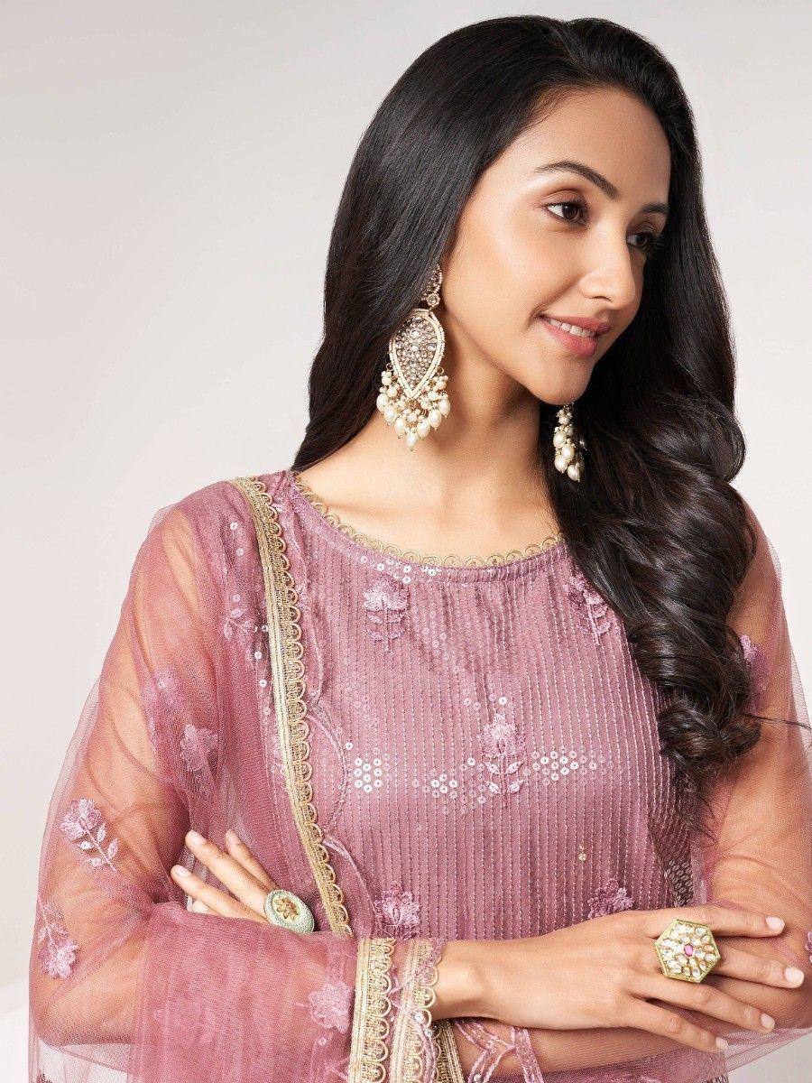 Pink embroidered ethnic kurta with gold trim, paired with statement earrings and rings, perfect for festive occasions.