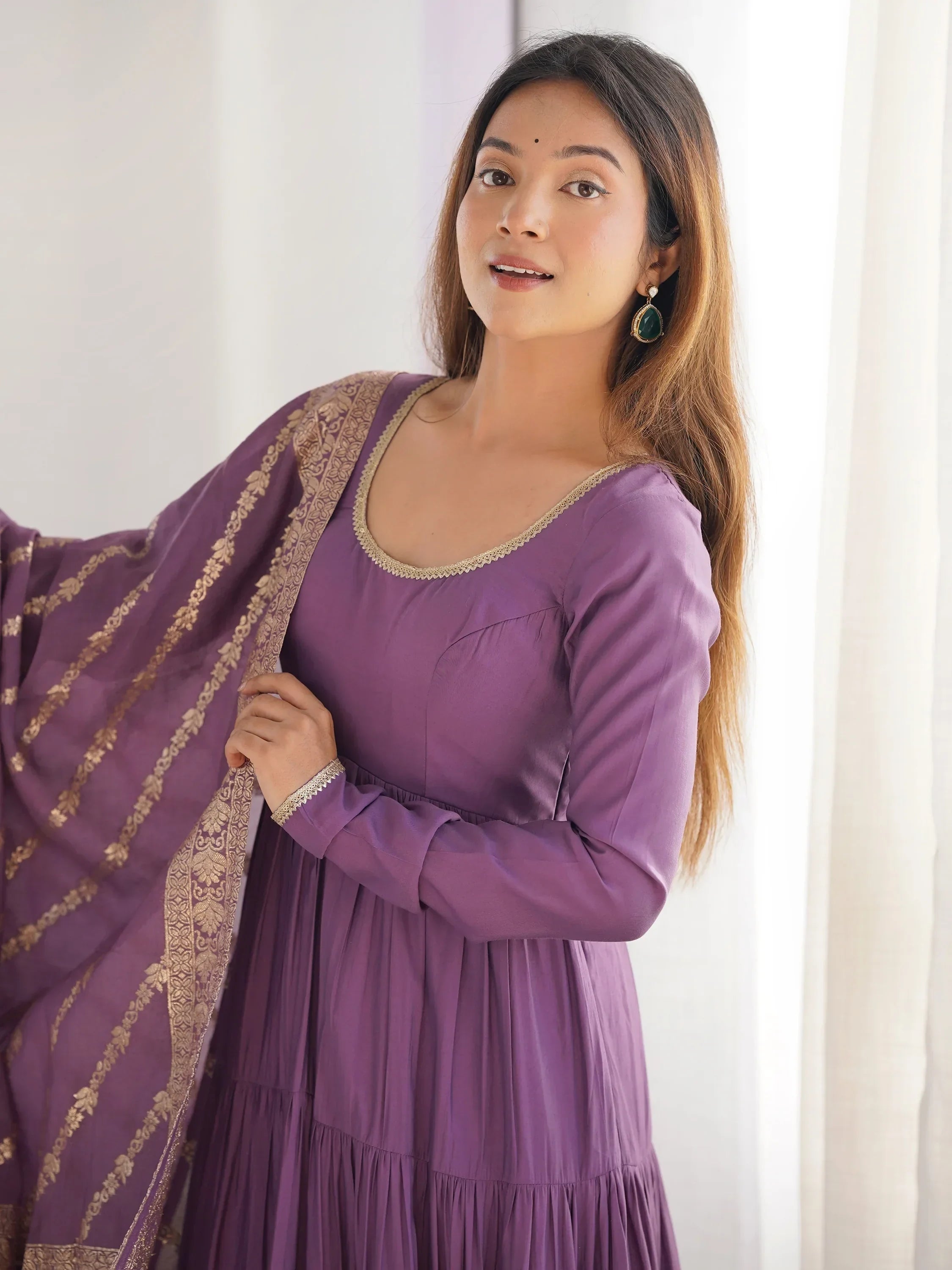 Woman in purple ethnic gown with gold embroidered dupatta, traditional Indian attire