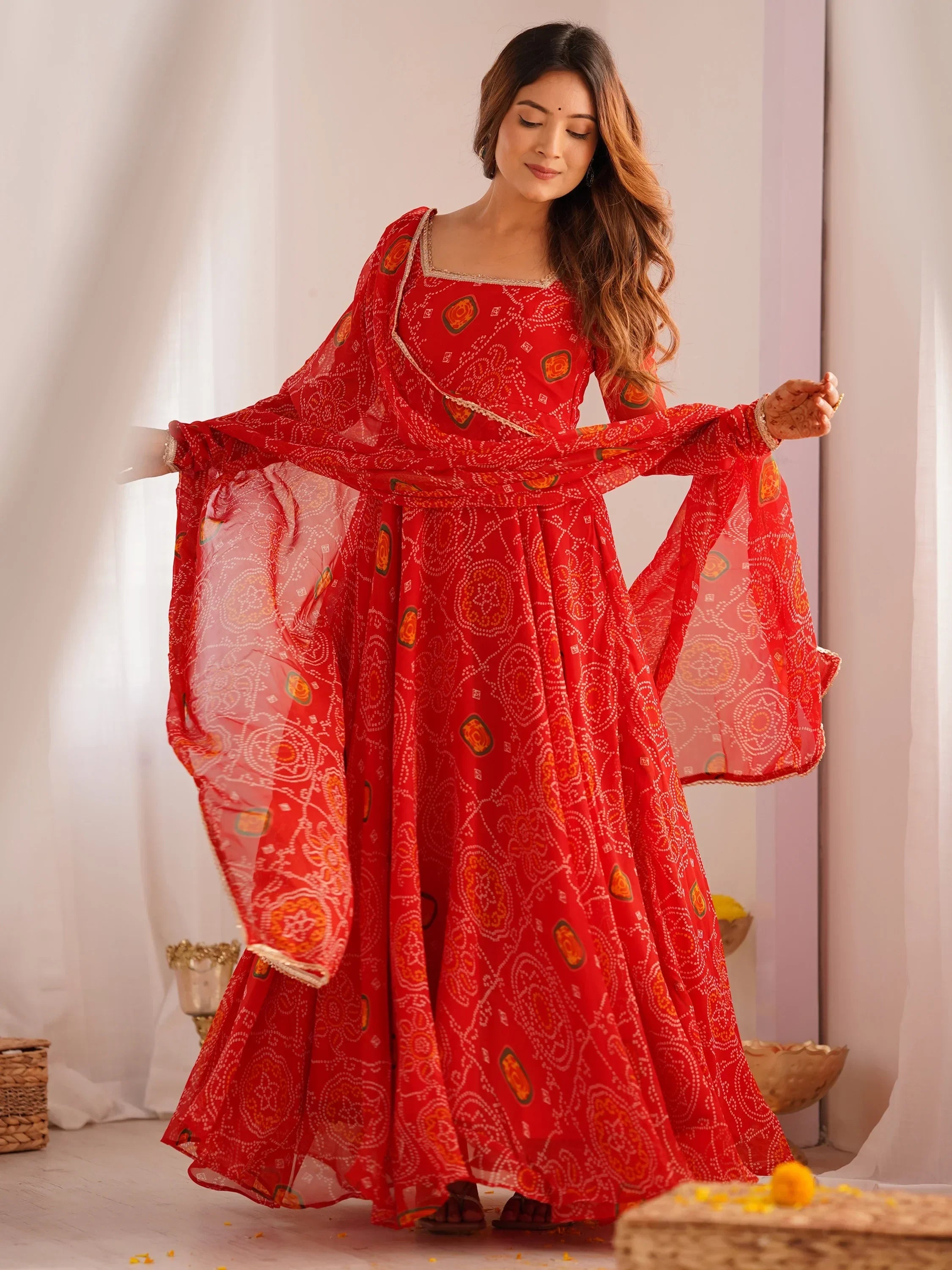 Woman in red printed ethnic gown with dupatta, Indian festive wear, indoor setting