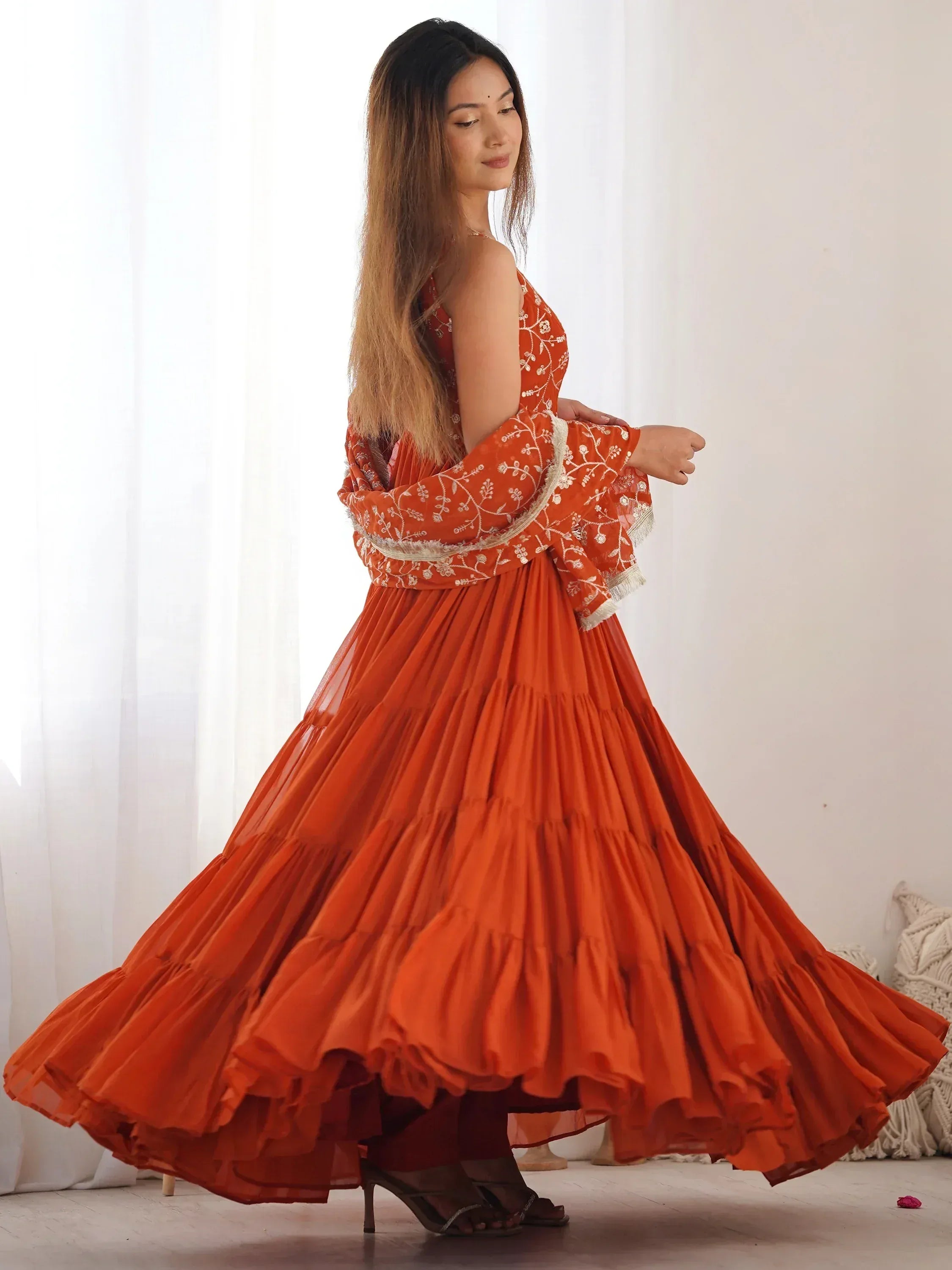 Orange embroidered ethnic gown with tiered skirt, perfect for Indian festive occasions