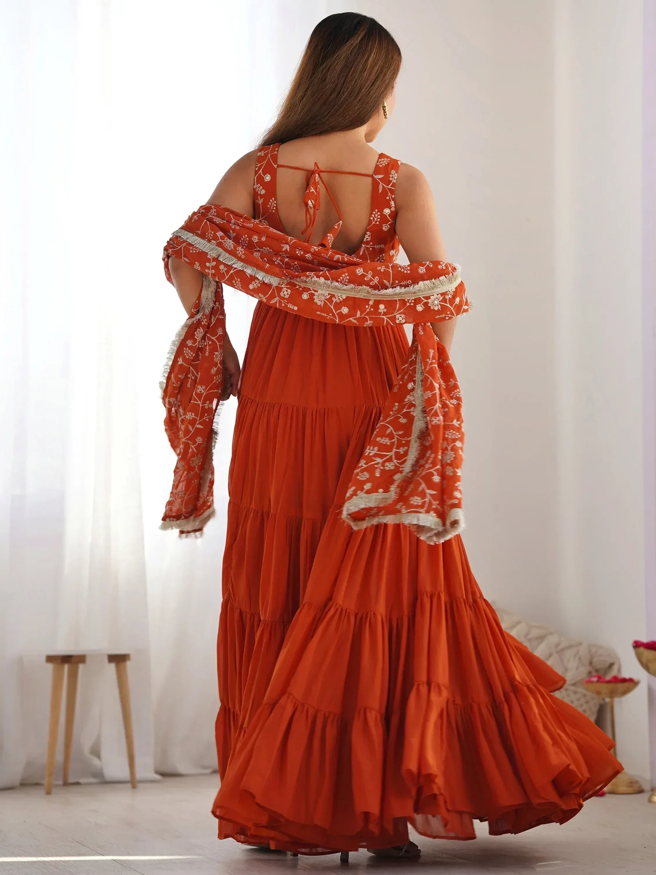 Orange tiered ethnic gown with floral embroidery and matching dupatta, back view
