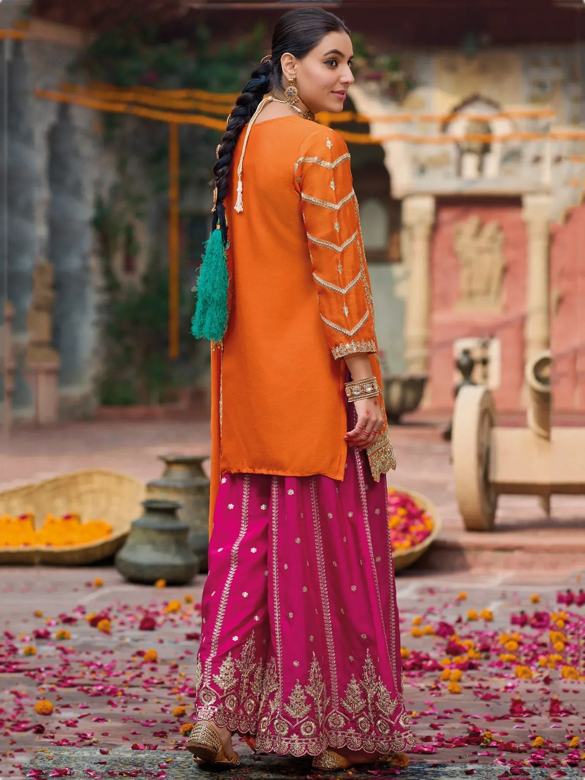 Orange and pink embroidered ethnic salwar kameez with gold detailing, perfect for festive occasions.