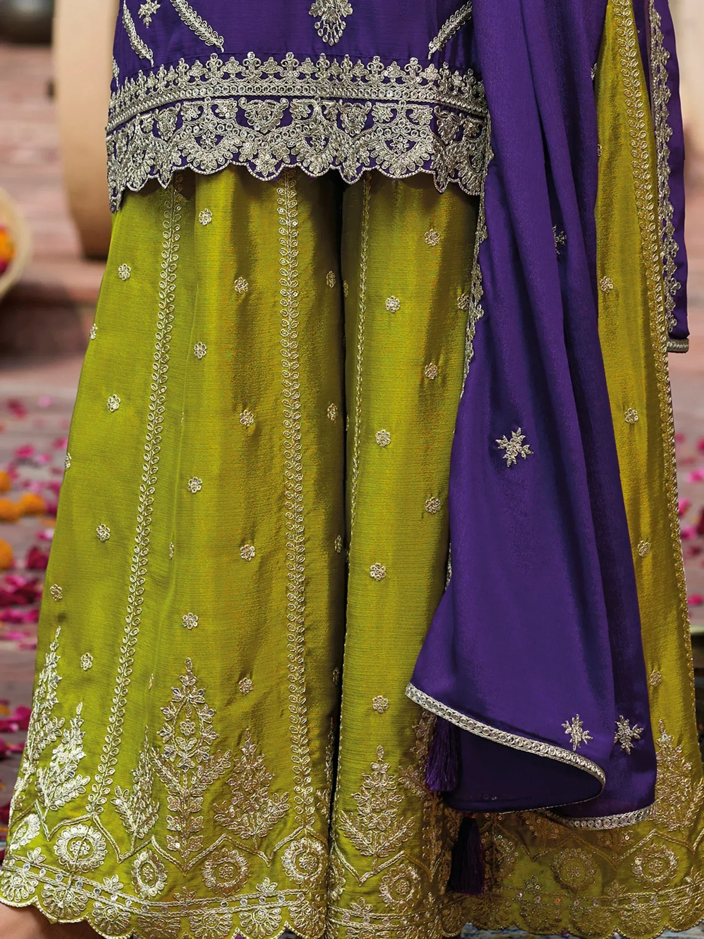 Purple and green embroidered ethnic wear with intricate gold detailing and scalloped hem