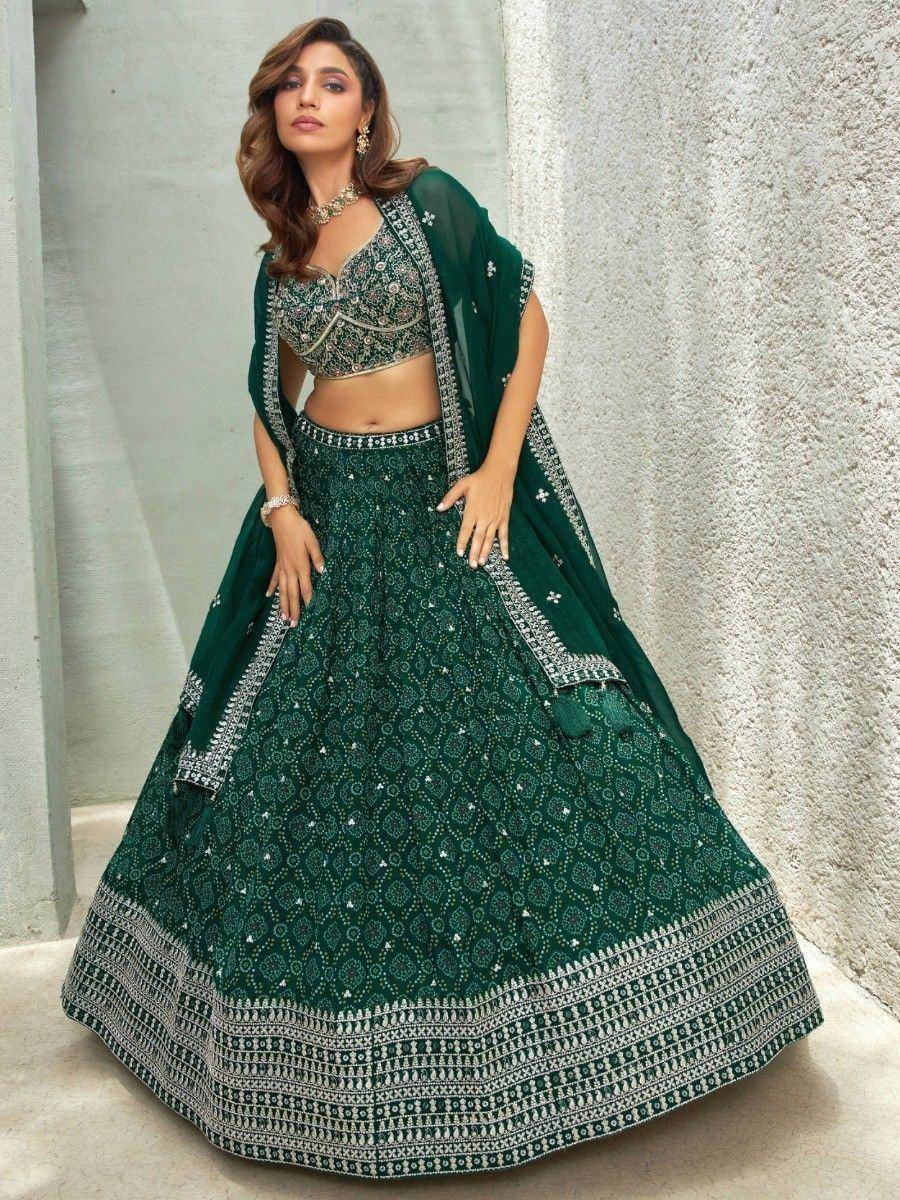 Emerald green designer lehenga choli with intricate embroidery and silver detailing, perfect for weddings and festive occasions.