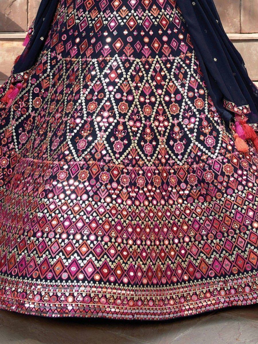 Indian ethnic lehenga with intricate mirror work and geometric embroidery in pink, red, and navy blue